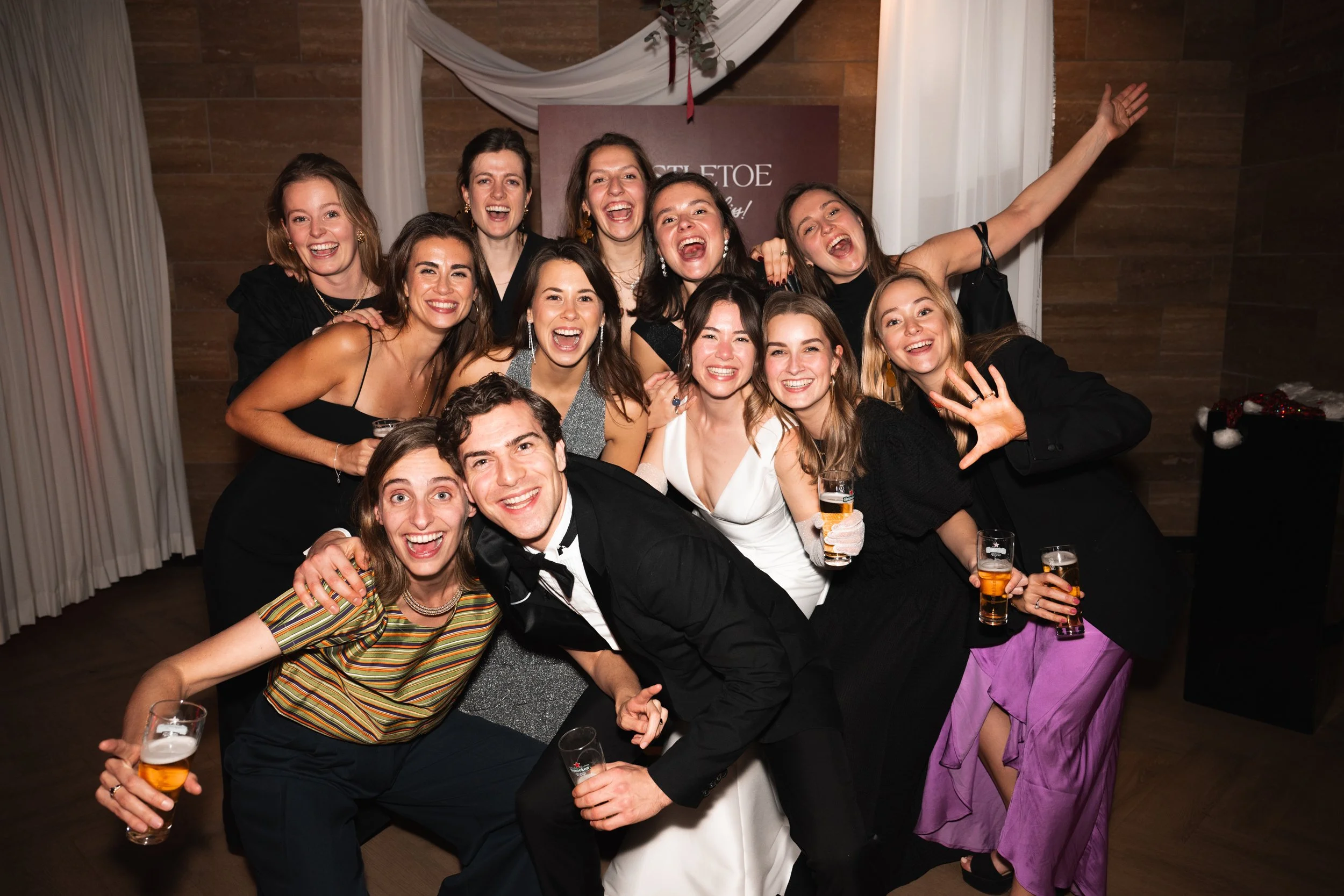 Group of people celebrating at a party, smiling, and holding drinks