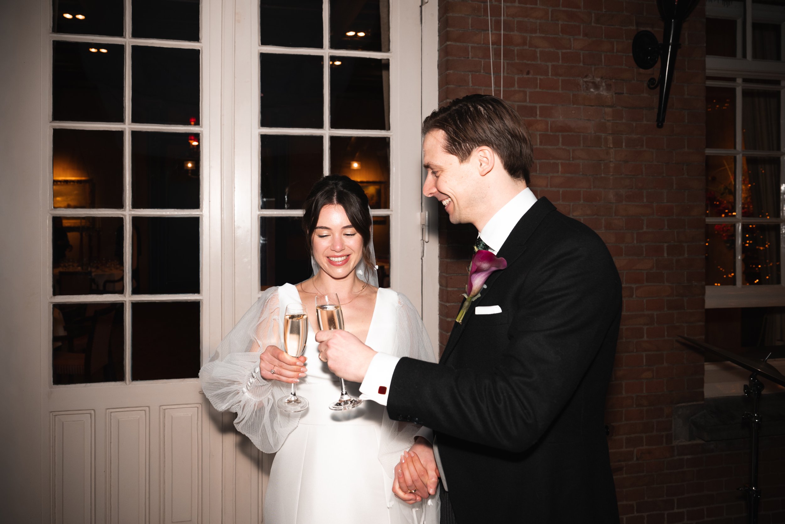 A bride and groom toasting with champagne glasses at their wedding reception.