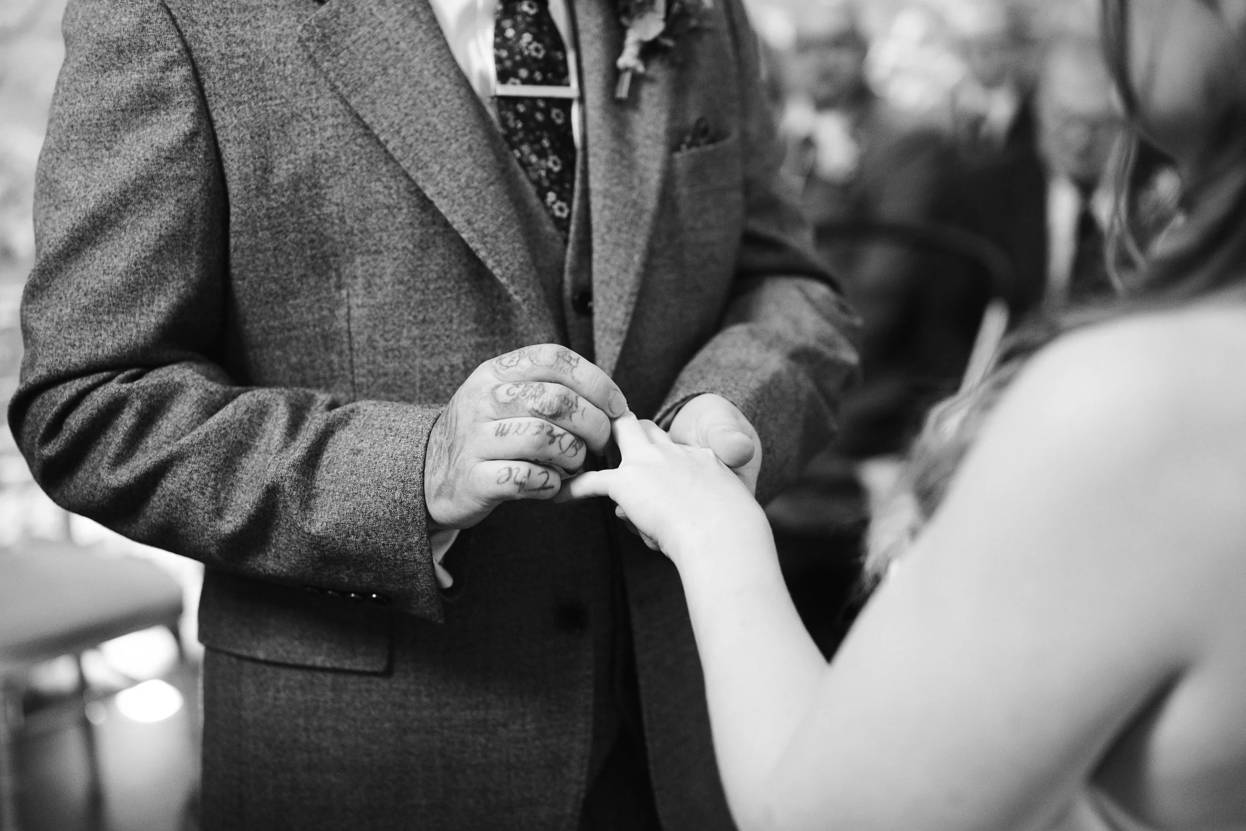 A man in a suit holding a child's hand at a wedding or formal event.