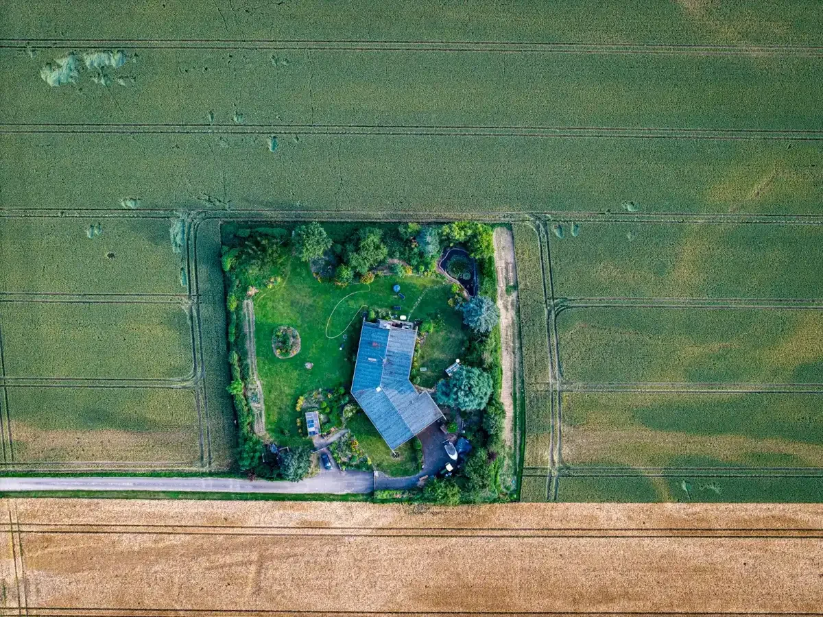 Maison isolée entourée de champs, vue aérienne