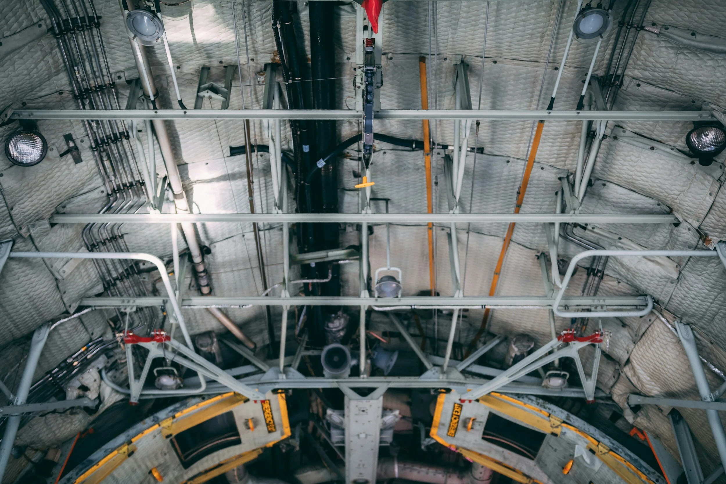 Interior of airplane cargo bay with metal framework and insulated walls.