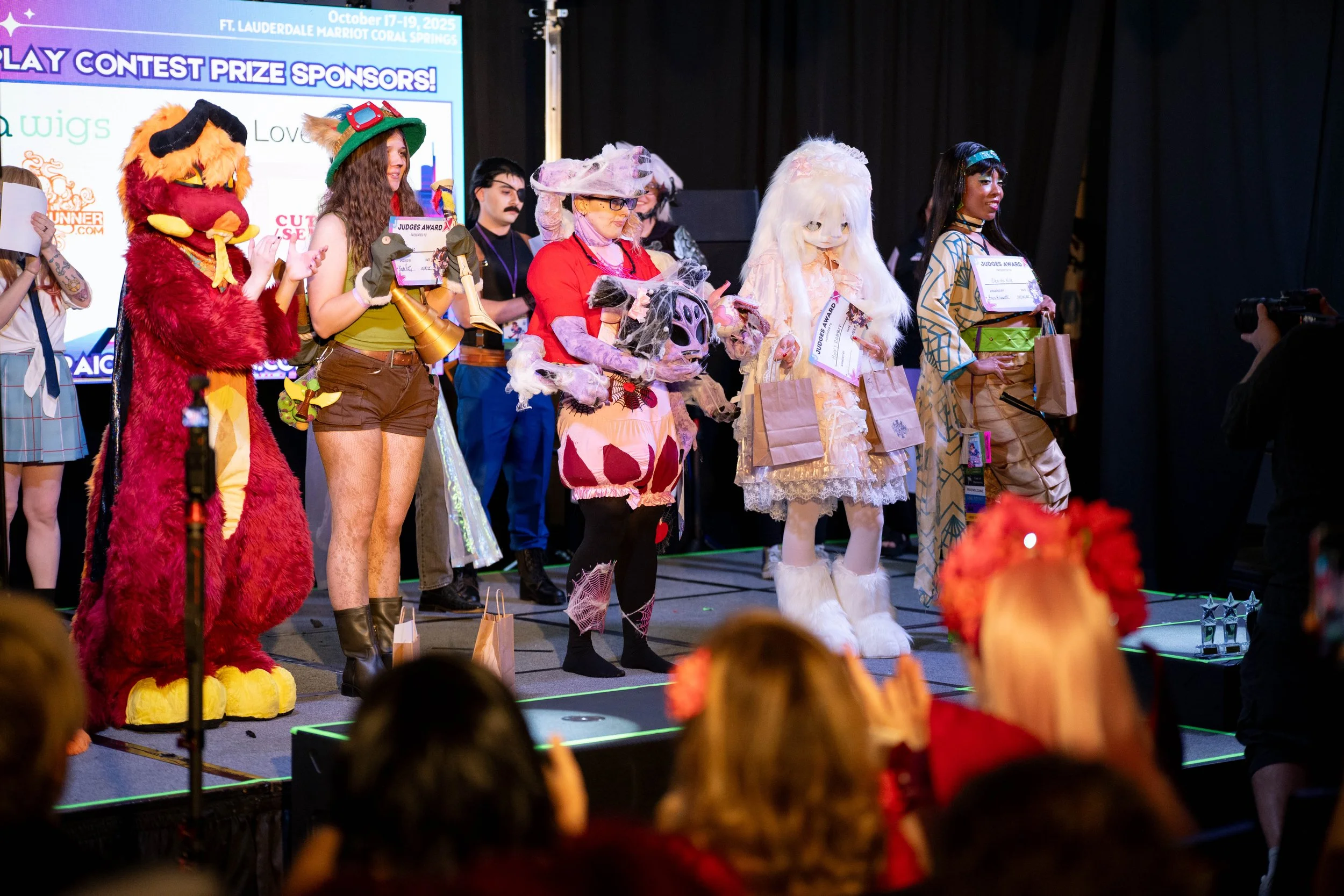 Colorful promotional poster for Miraicon featuring three cosplayers dressed as characters from anime or video games. The poster announces that applications are now open, with a deadline of August 1.