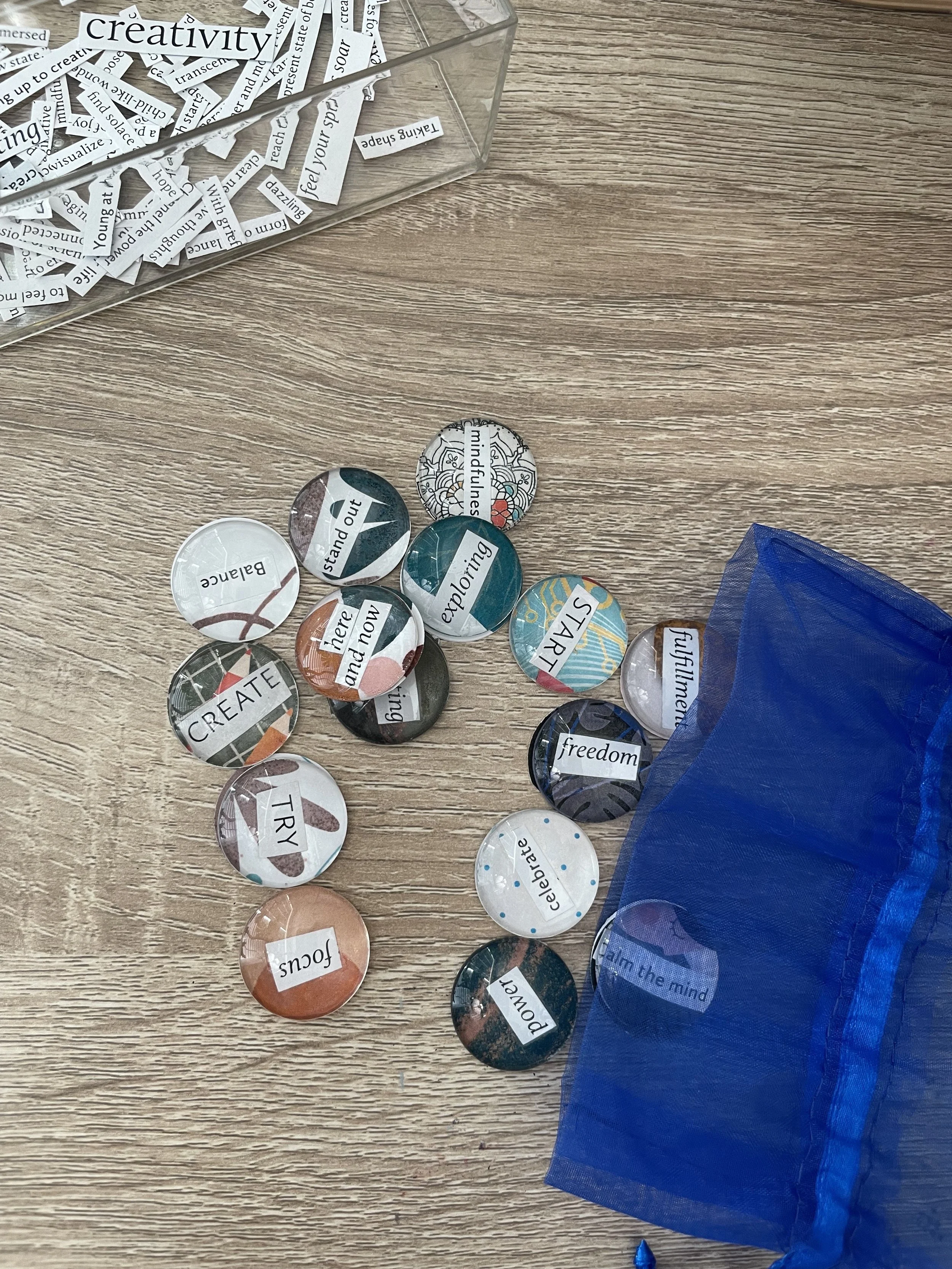 A group of hands holding colorful, handmade Inspiration Stones with affirmations, symbolizing grounding, connection, and social engagement in art therapy.