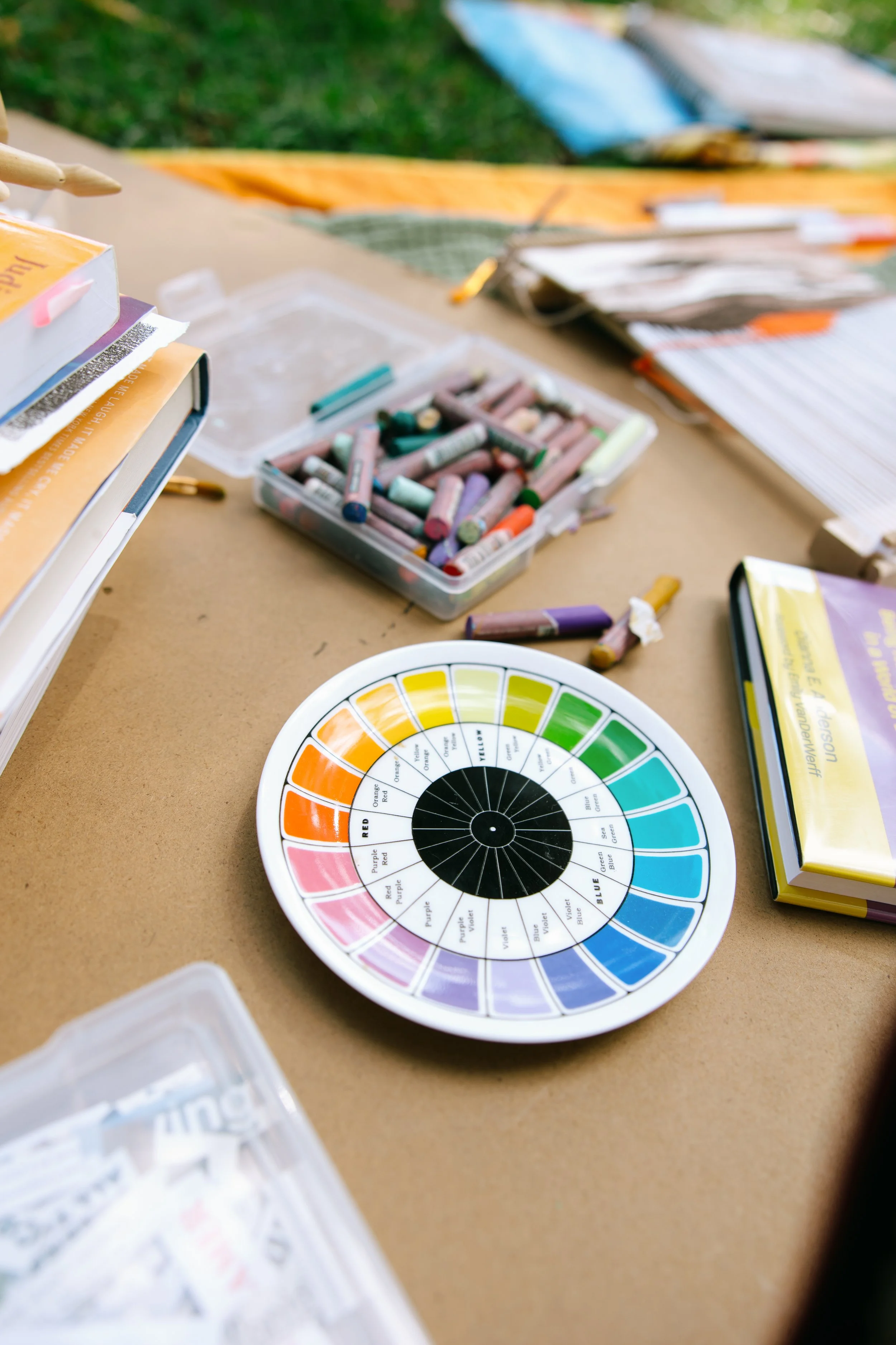 Maryland art therapist Kristy Leone at Labyrinth Art and Wellness setting up their art therapy room before a therapy session with oil pastels, painting supplies, and collage materials.