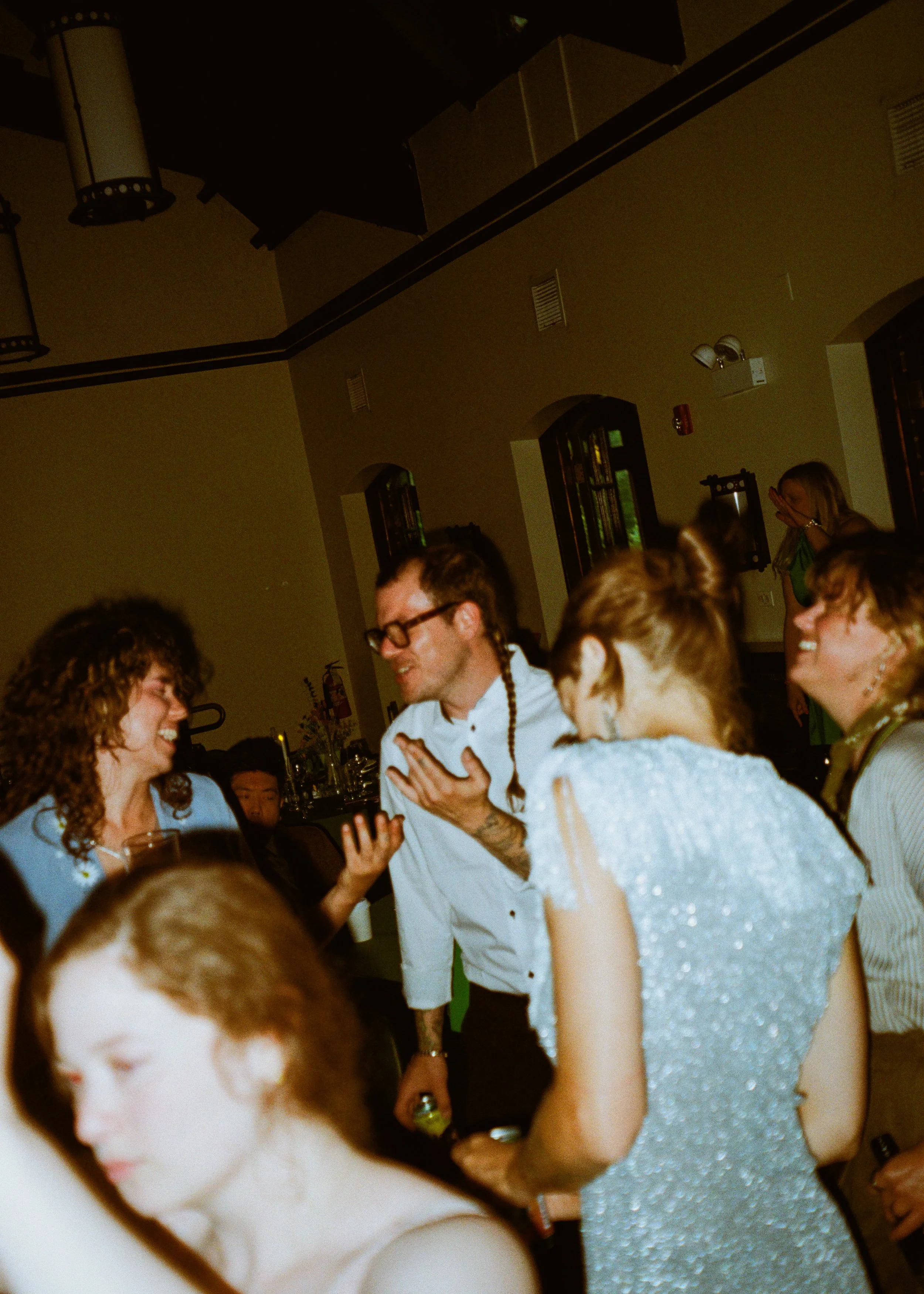 People dancing and socializing at a party or celebration indoors.