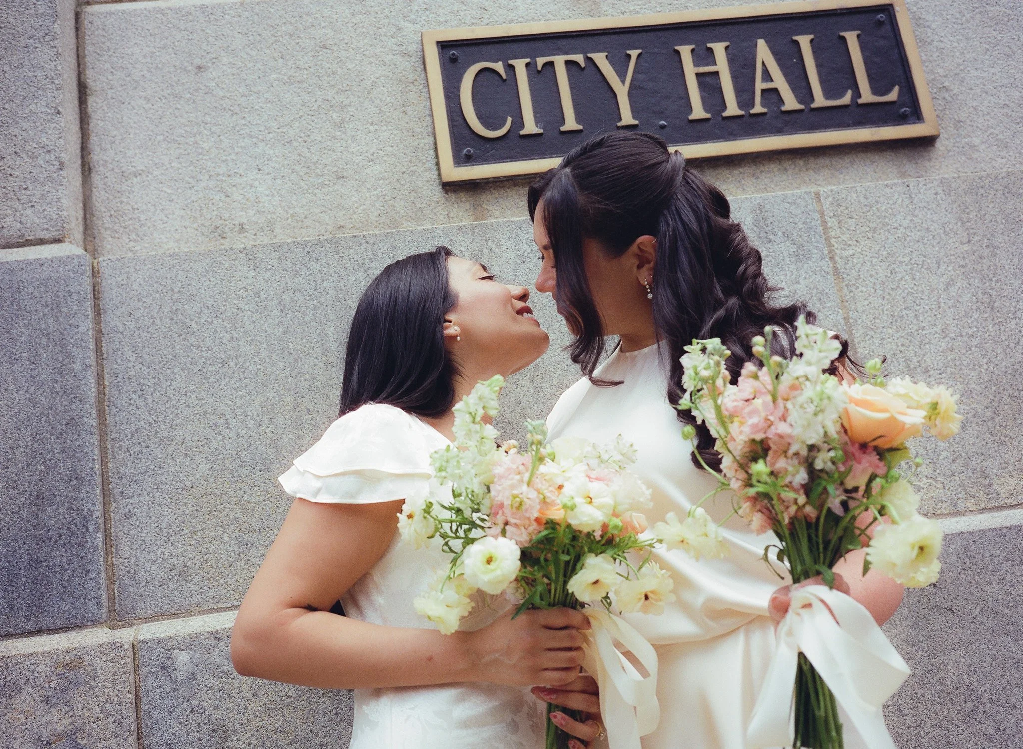 two wives going to kiss at City Hall elopement