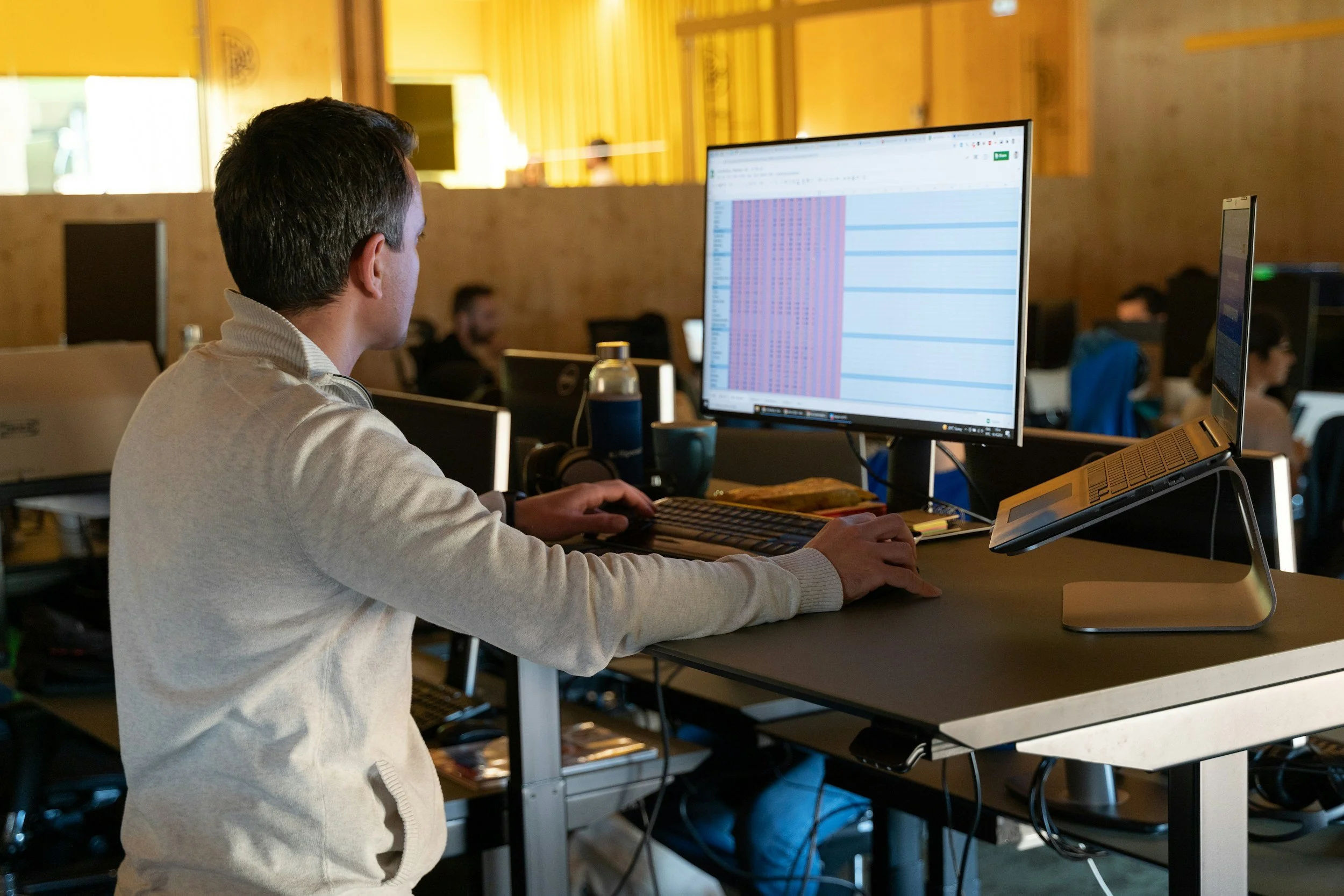 man sitting at a desk at work looking at a computer screen