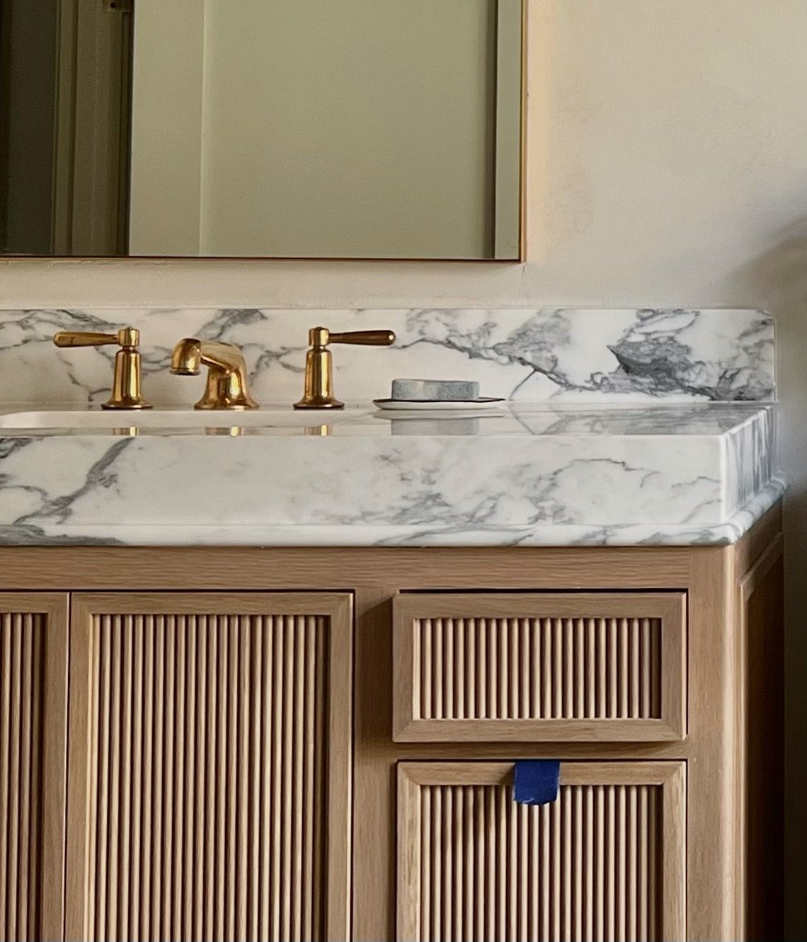 Bathroom vanity details. 

Unlaquered brass faucets and reeded cabinet fronts has us excited 🤎