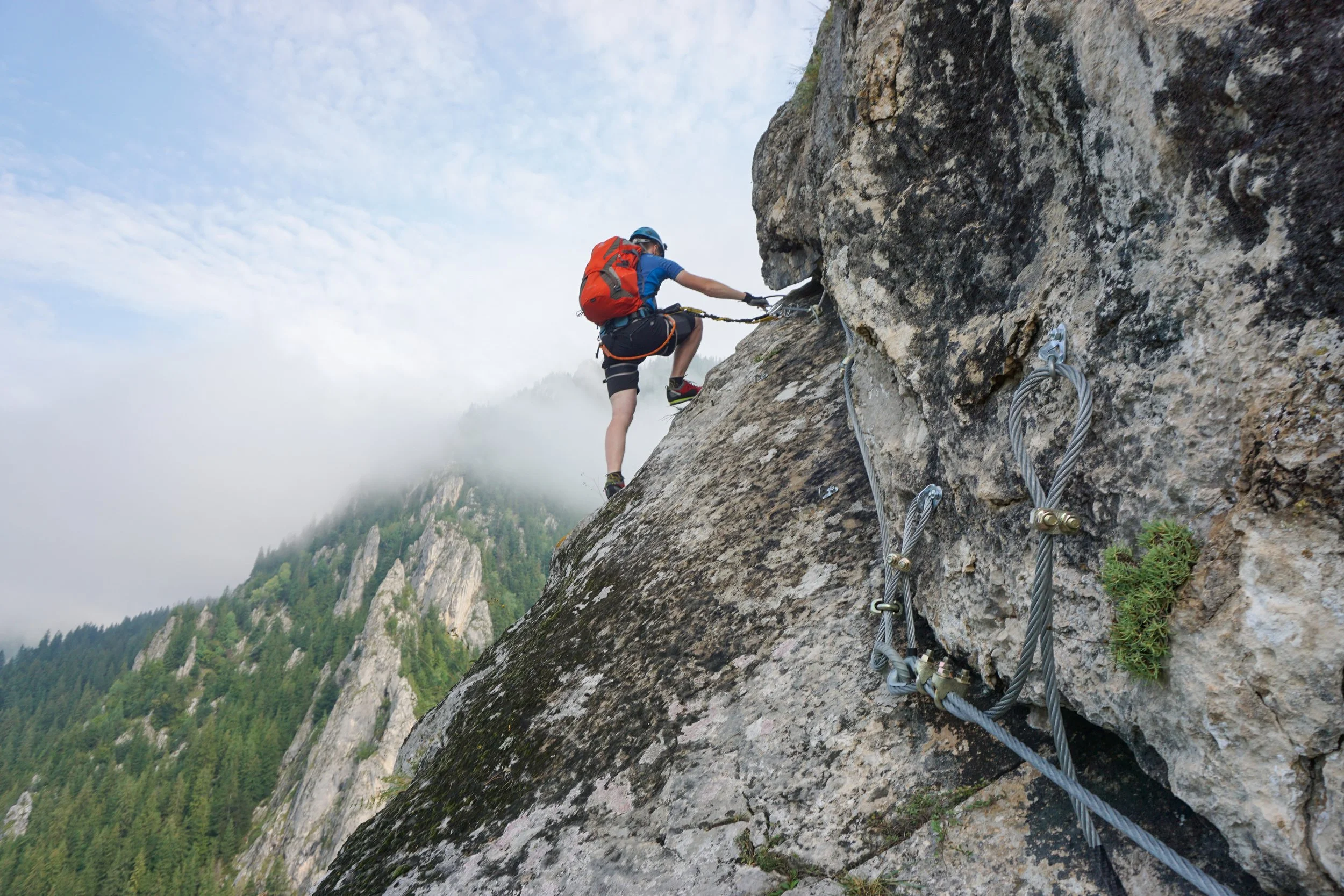 stunning-shot-young-man-climbing-up-cliff-cold-foggy-day.jpg