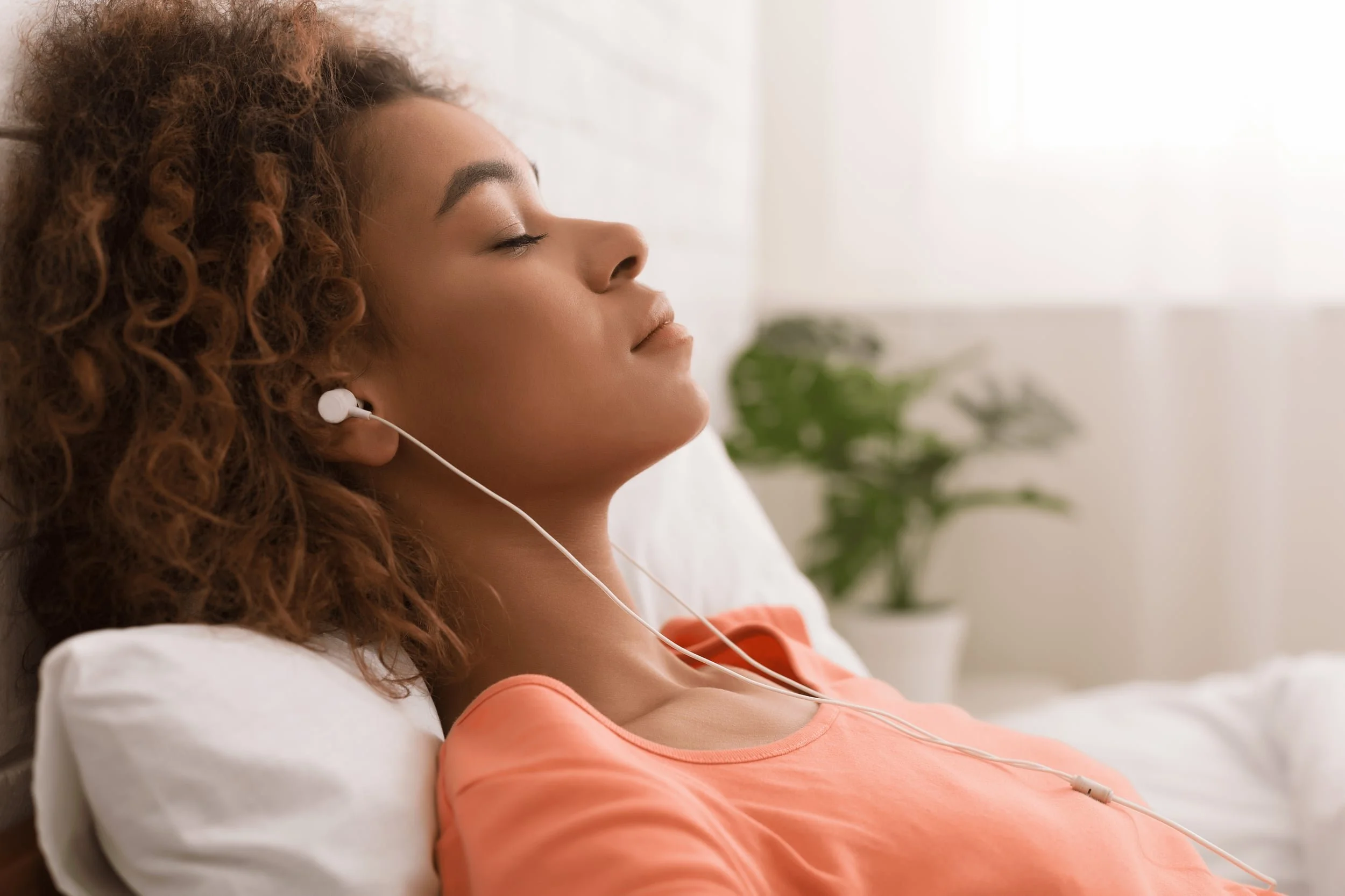 Person resting with eyes closed and headphones on, representing EMDR therapy and processing trauma in a calm, focused state