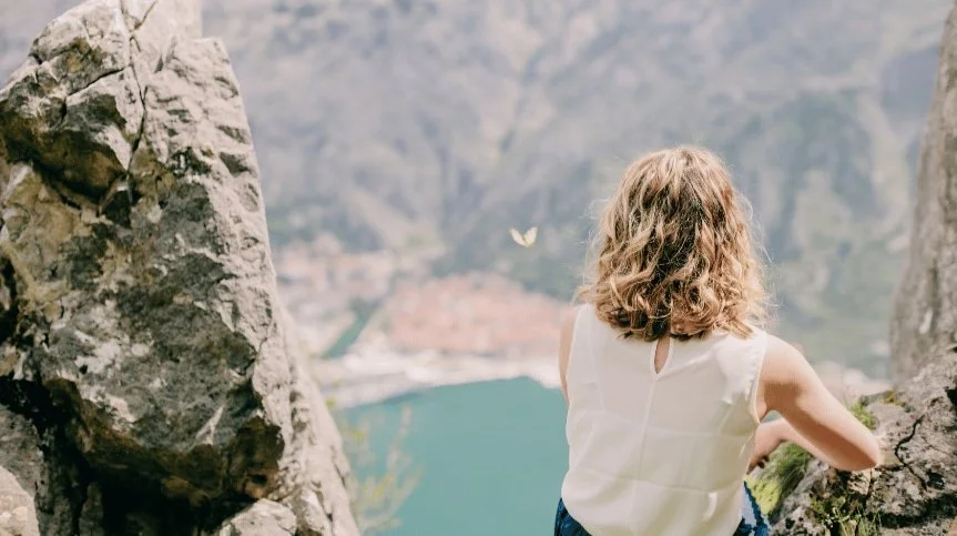 Person standing in nature looking outward, representing how  childhood trauma can still feel present in adulthood and the process of healing through EMDR therapy