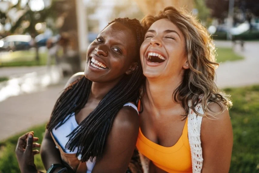 Two women laughing together and feeling connected, representing life after healing from childhood trauma