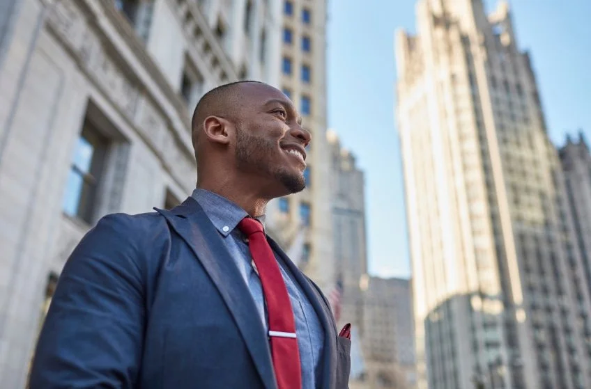 Man standing in a city looking calm and confident, representing clarity and understanding after working through childhood trauma