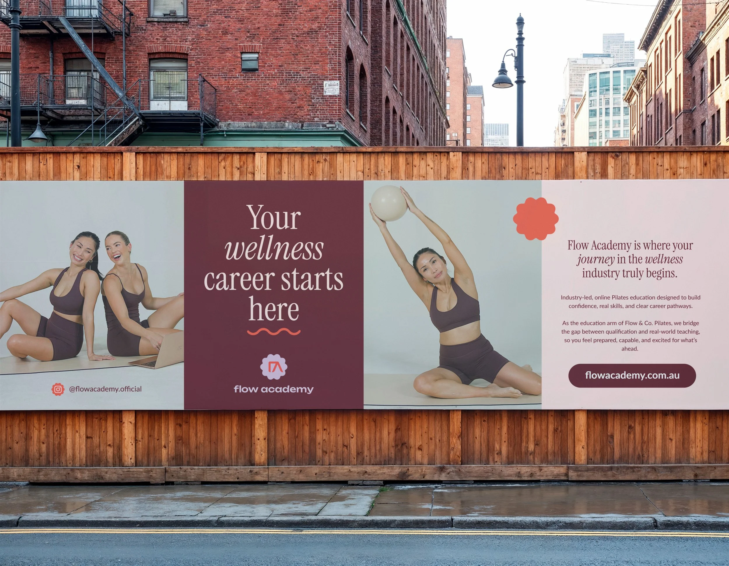 A large outdoor billboard promoting Flow Academy, a wellness and career development organization, features three women practicing yoga poses. The background shows brick buildings and city skyscrapers.