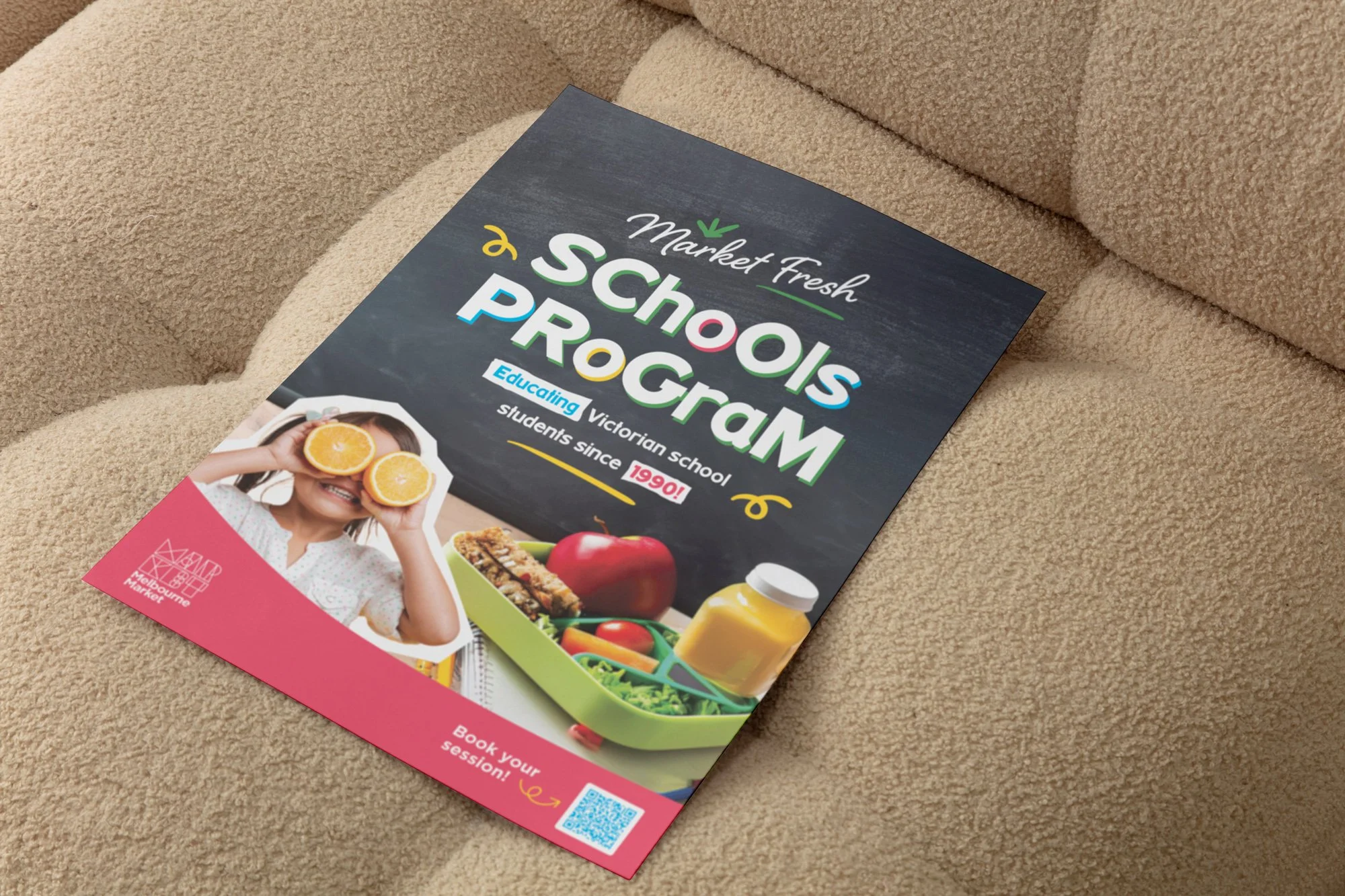 Freelance Graphic Designer Melbourne. Flyer titled 'Market Fresh Schools Program' featuring a girl holding orange slices over her eyes, a lunchbox with an apple, salad, and bottle of juice, on a pink and dark background.