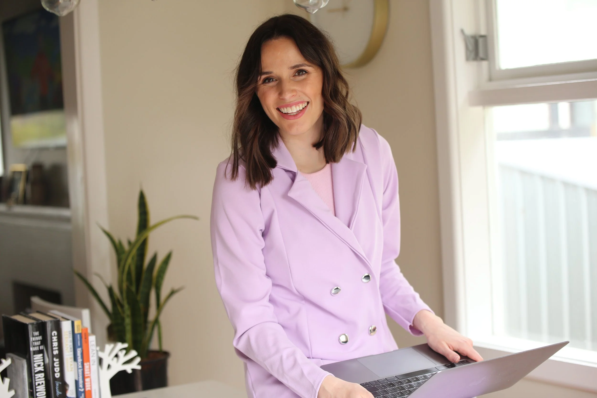 Jess Philips, founder of Cosmic Copy, wearing purple blazer and smiles to camera.