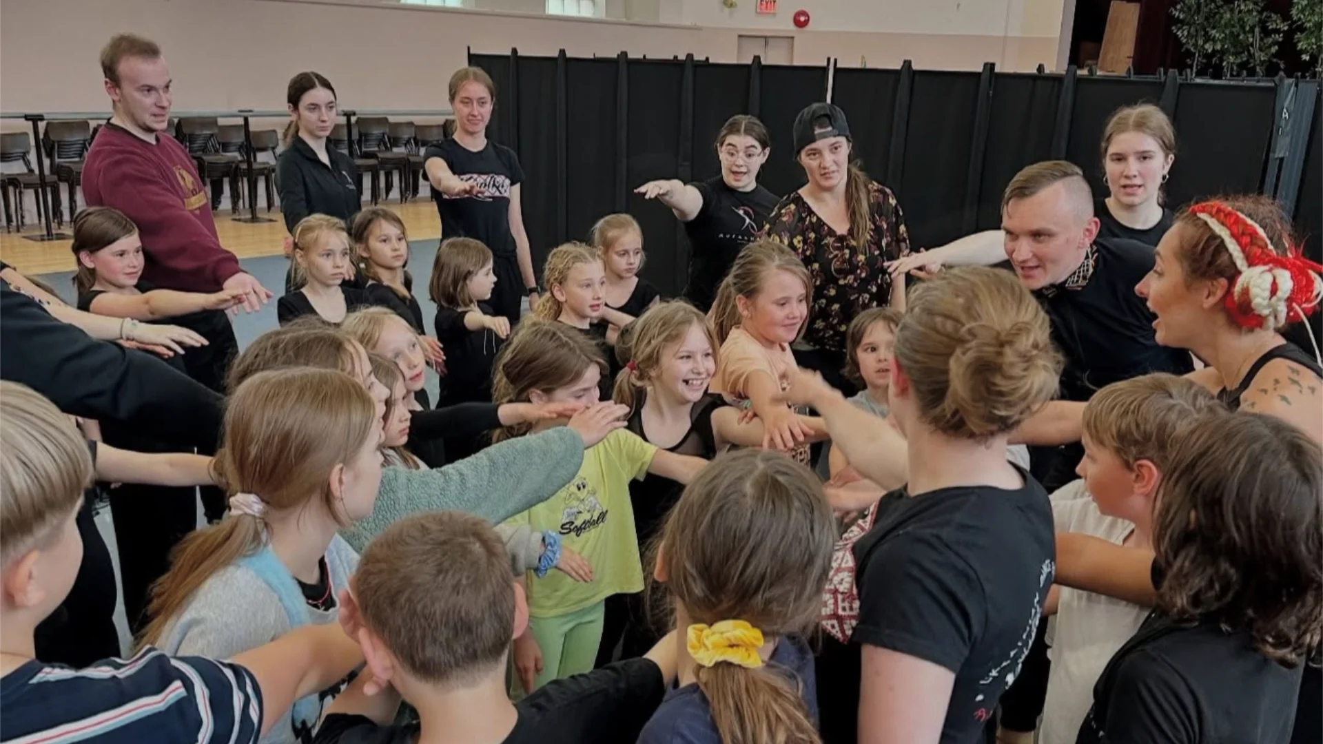 Senior Rusalka dancer engaging with a group of children during a dance workshop