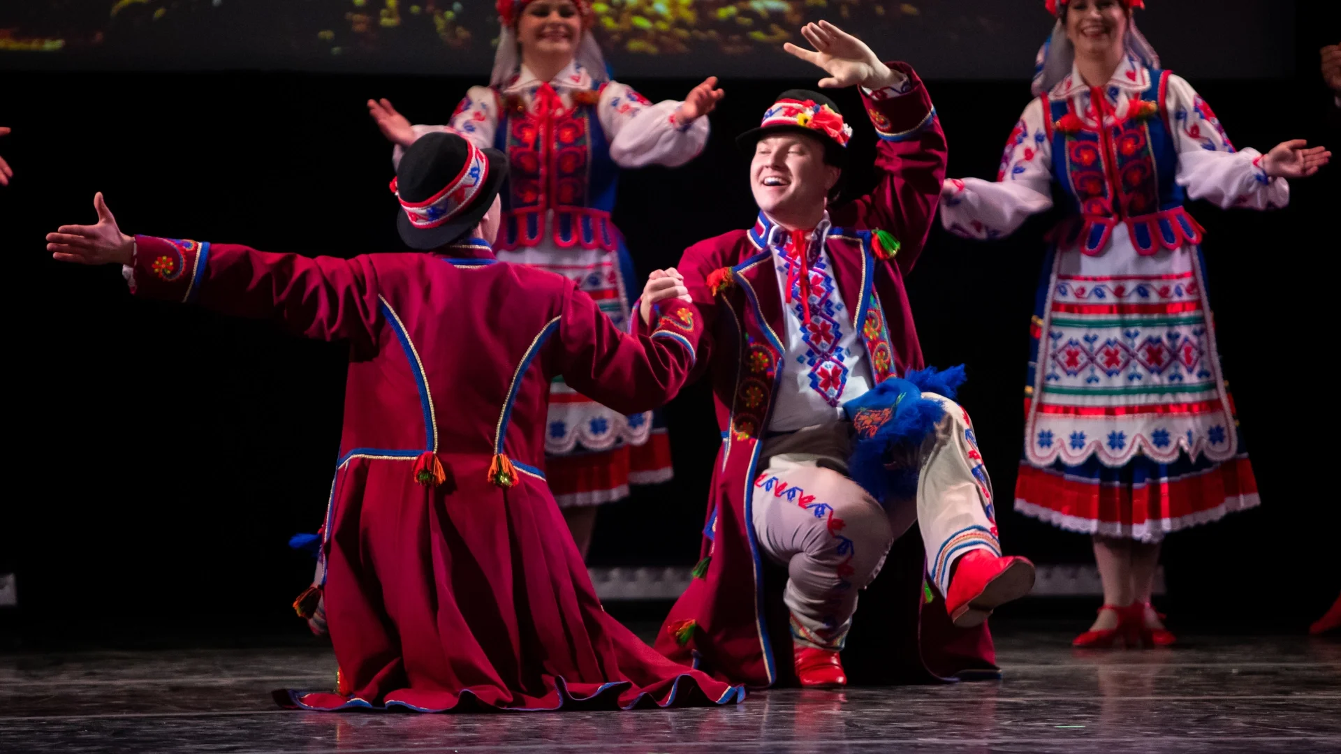 Rusalka Ukrainian Dance Ensemble performers in vibrant embroidered costumes executing a joyful stage routine from a traditional Ukrainian dance in Winnipeg