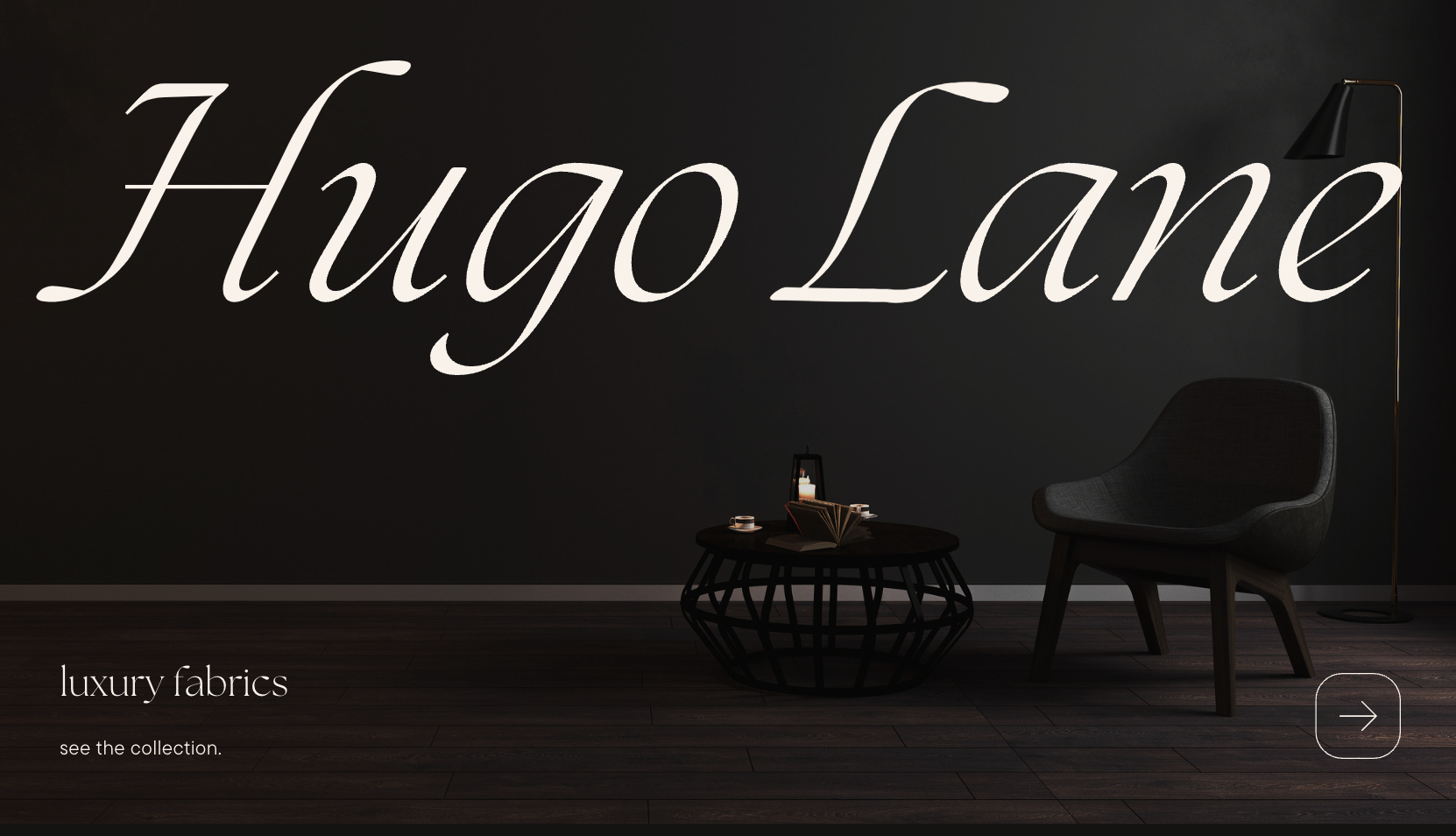 Dark modern interior with large white cursive text reading 'Hugo Lane' on the wall, a black armchair, a round black coffee table with a lantern, open book, and cups, and a tall black floor lamp with a gold stand. Small text in the bottom left says 'l
