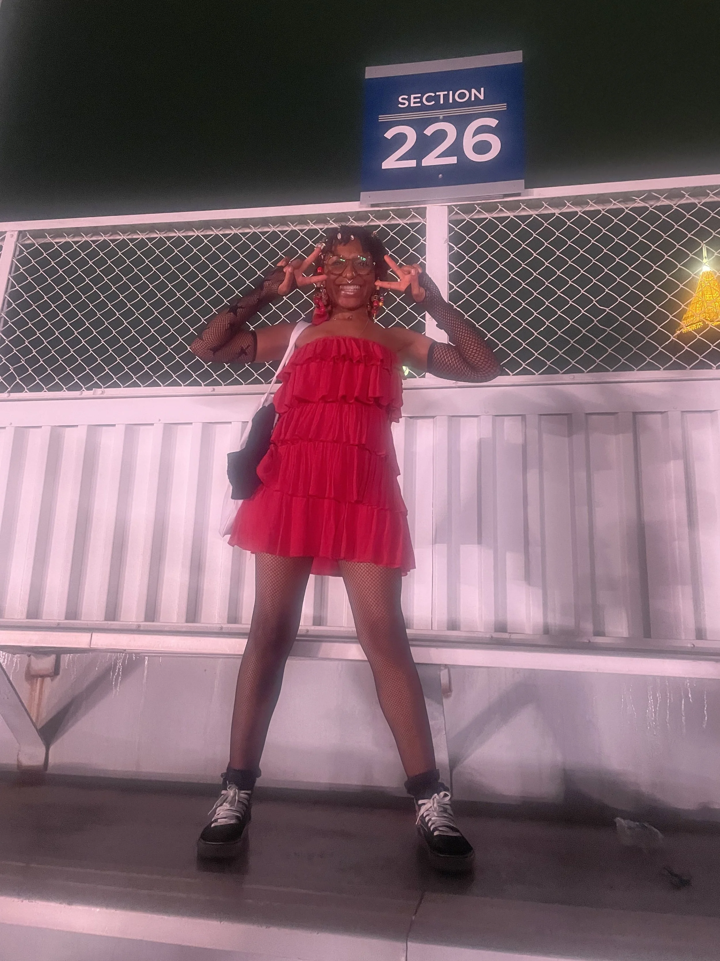 Afromuse Arts photographed at Bruno Mars Concert in double peace sign pose.