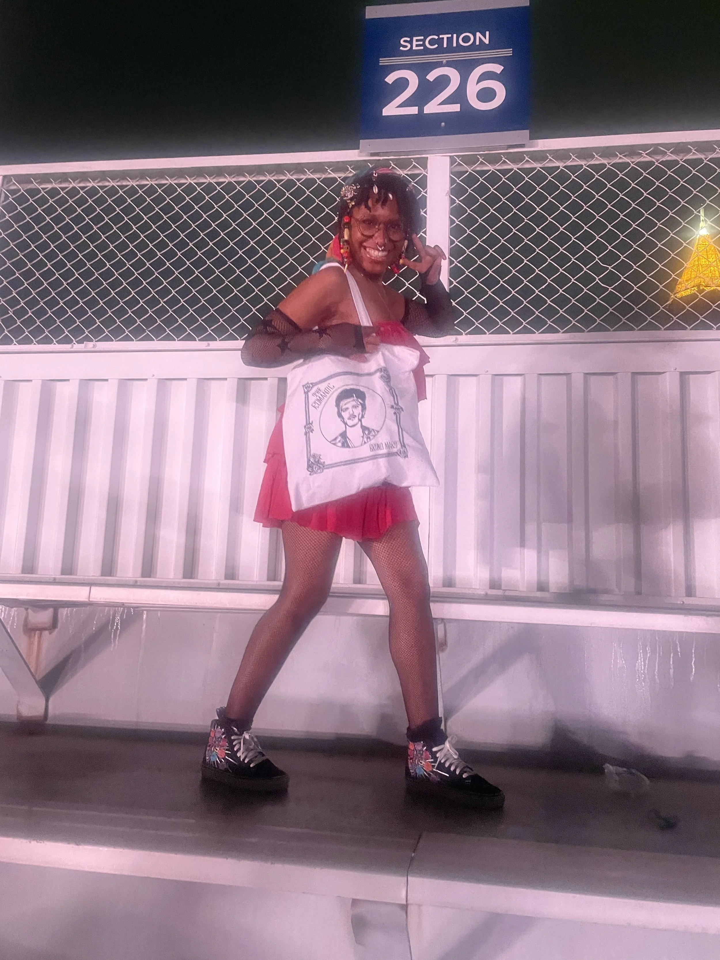 Afromuse Arts photographed at Bruno Mars Concert with merch.