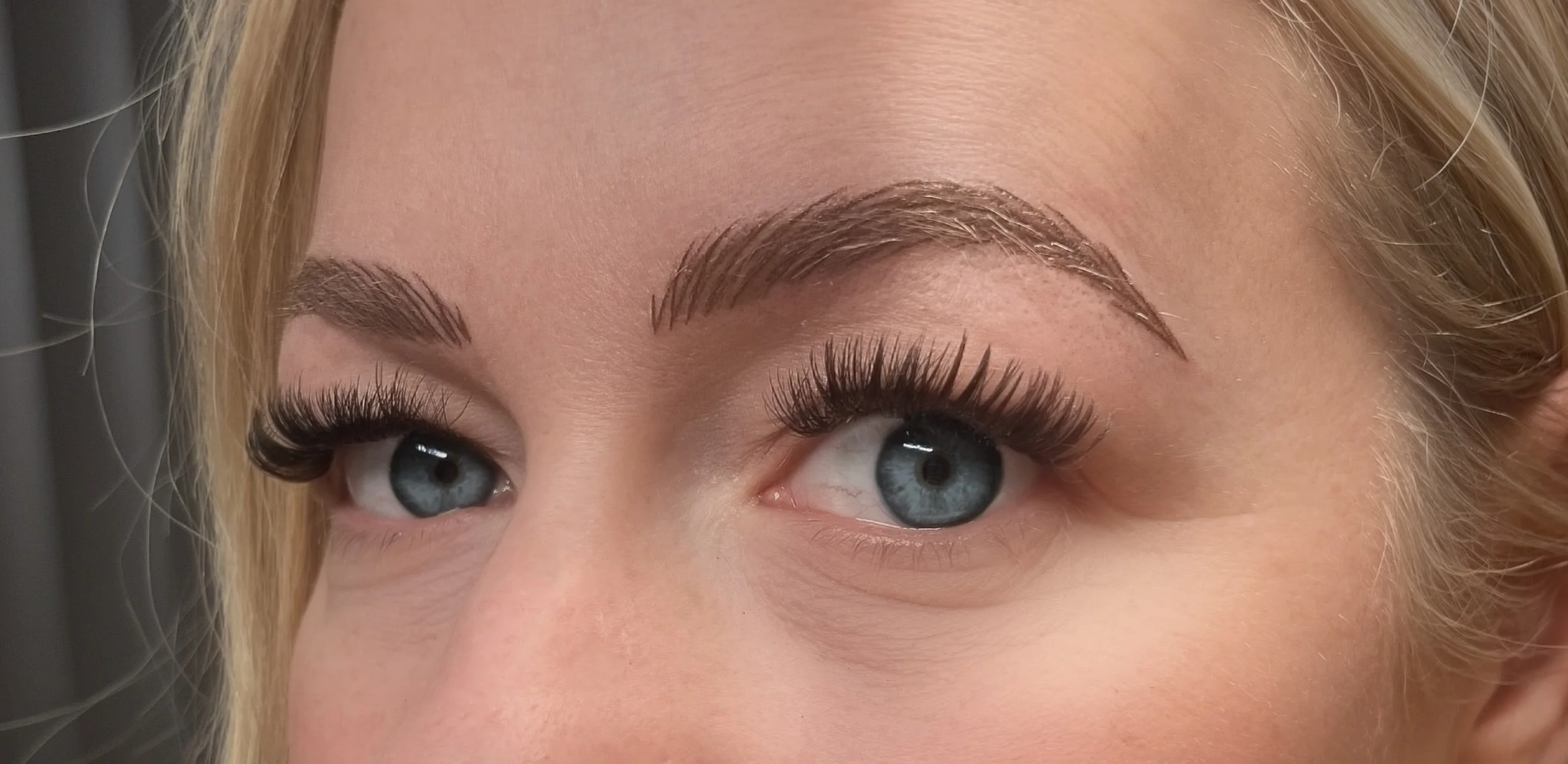 Side-by-side comparison of a woman's face, showing before and after makeup application, highlighting differences in eye makeup, skin tone, and facial features.
