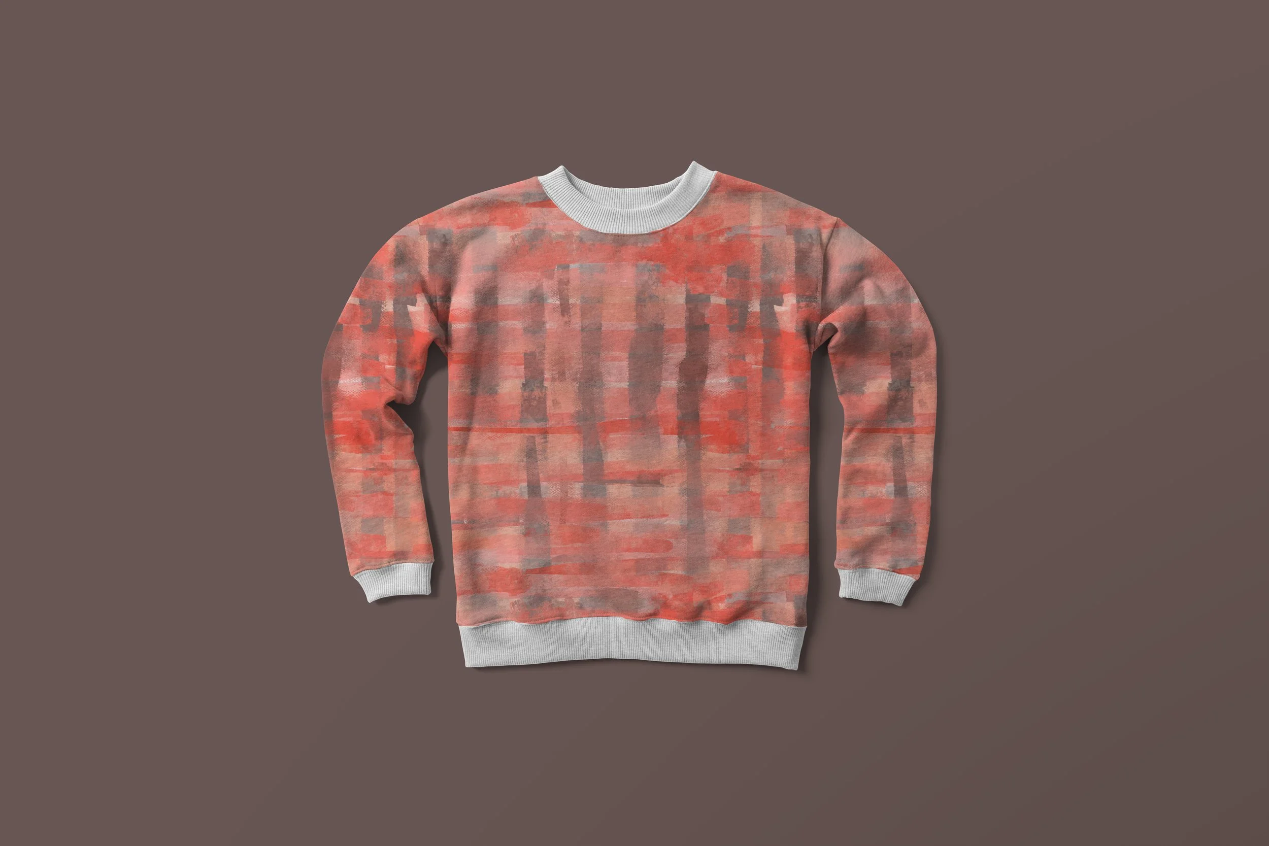 Pink and gray patterned sweatshirt with a round neckline and ribbed cuffs, laid flat against a brown background.