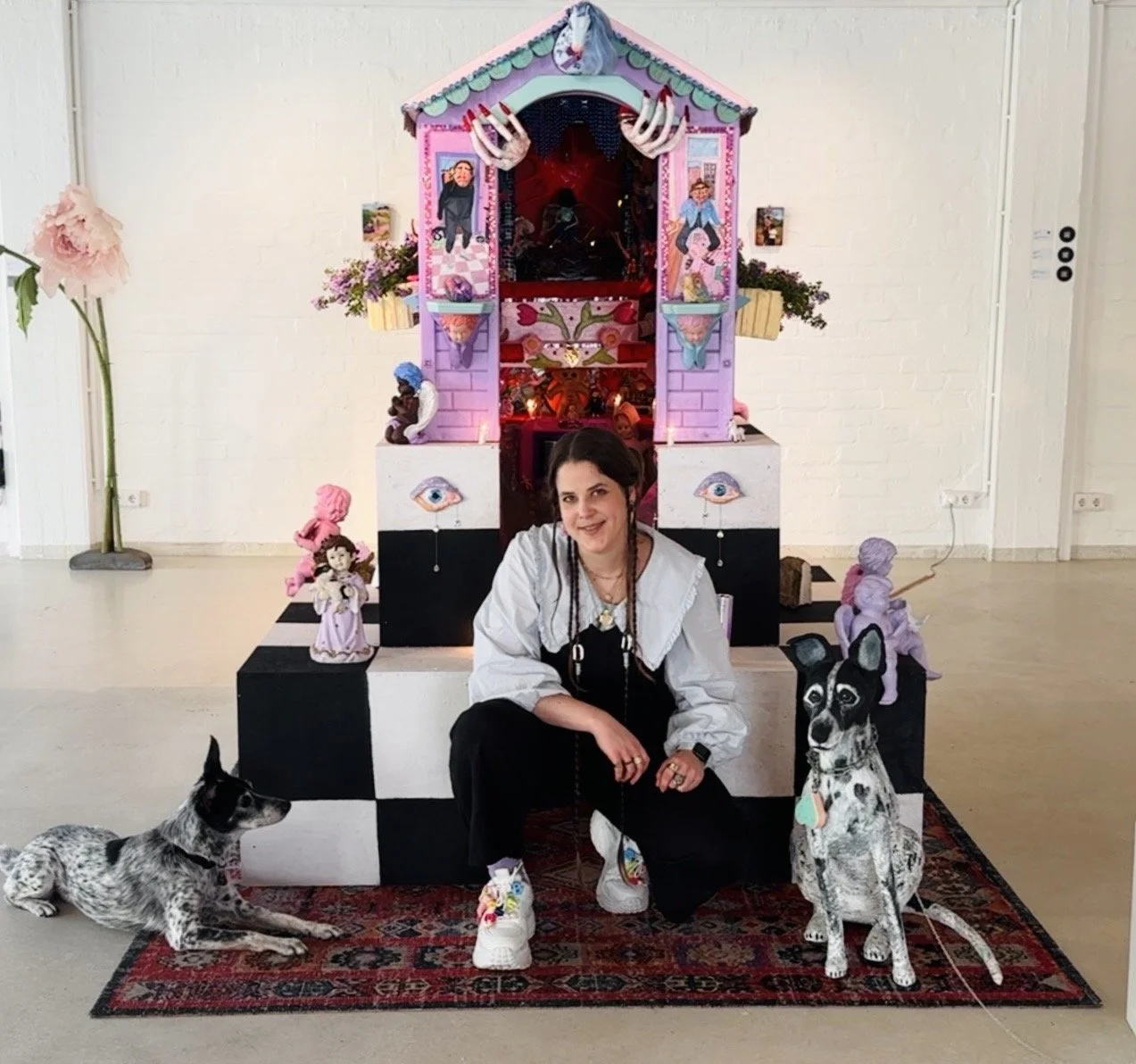 Artist kneeling in front of an art installation
