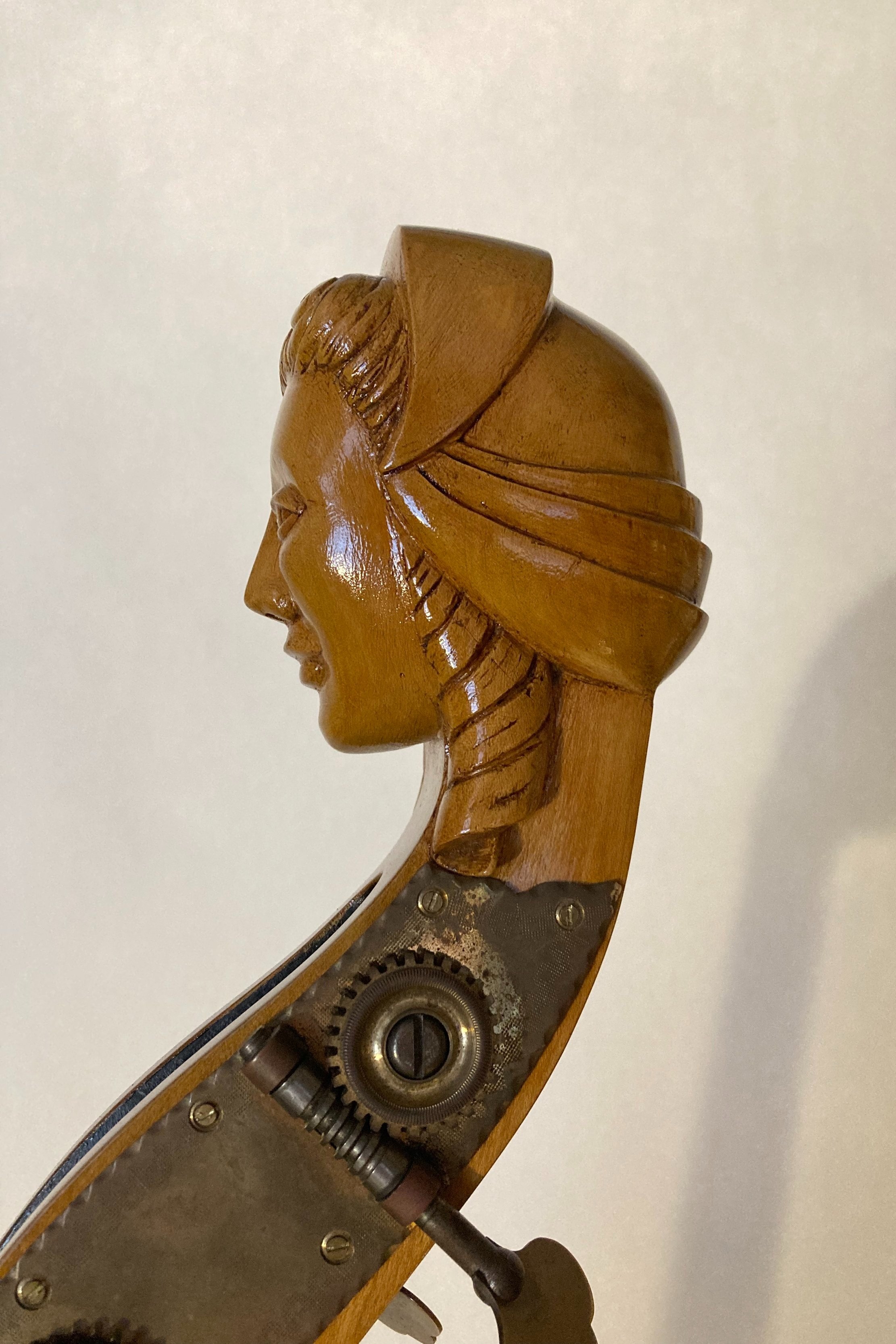 Carved woman's head at the top of bass.