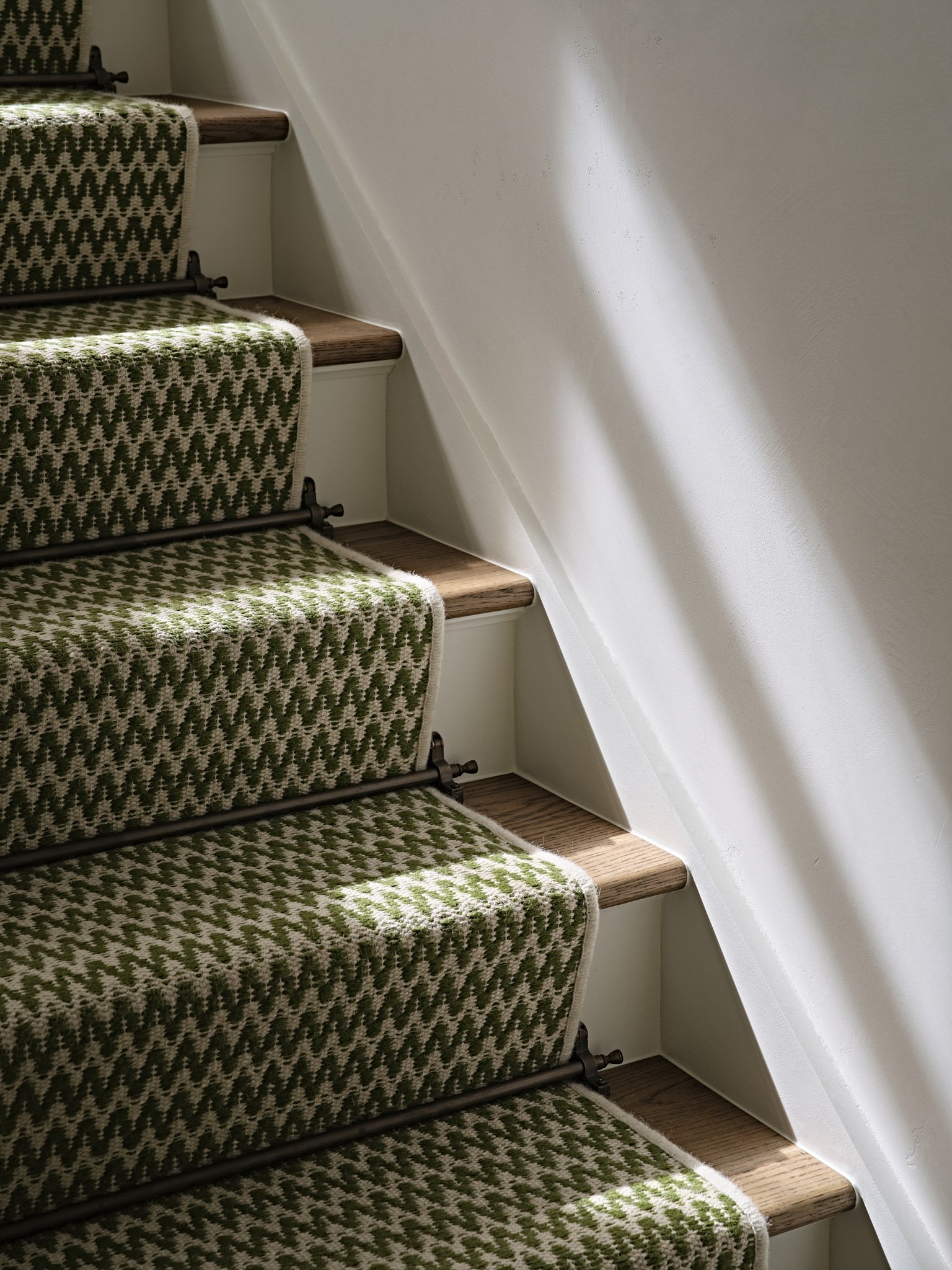 Detail of green staircase runner with sunlight, designed by Bryan O'Sullivan Studio