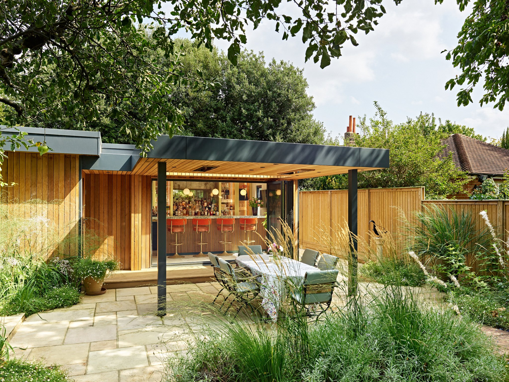 Outhouse garden bar with orange barstools, interior design by Carden Cunietti