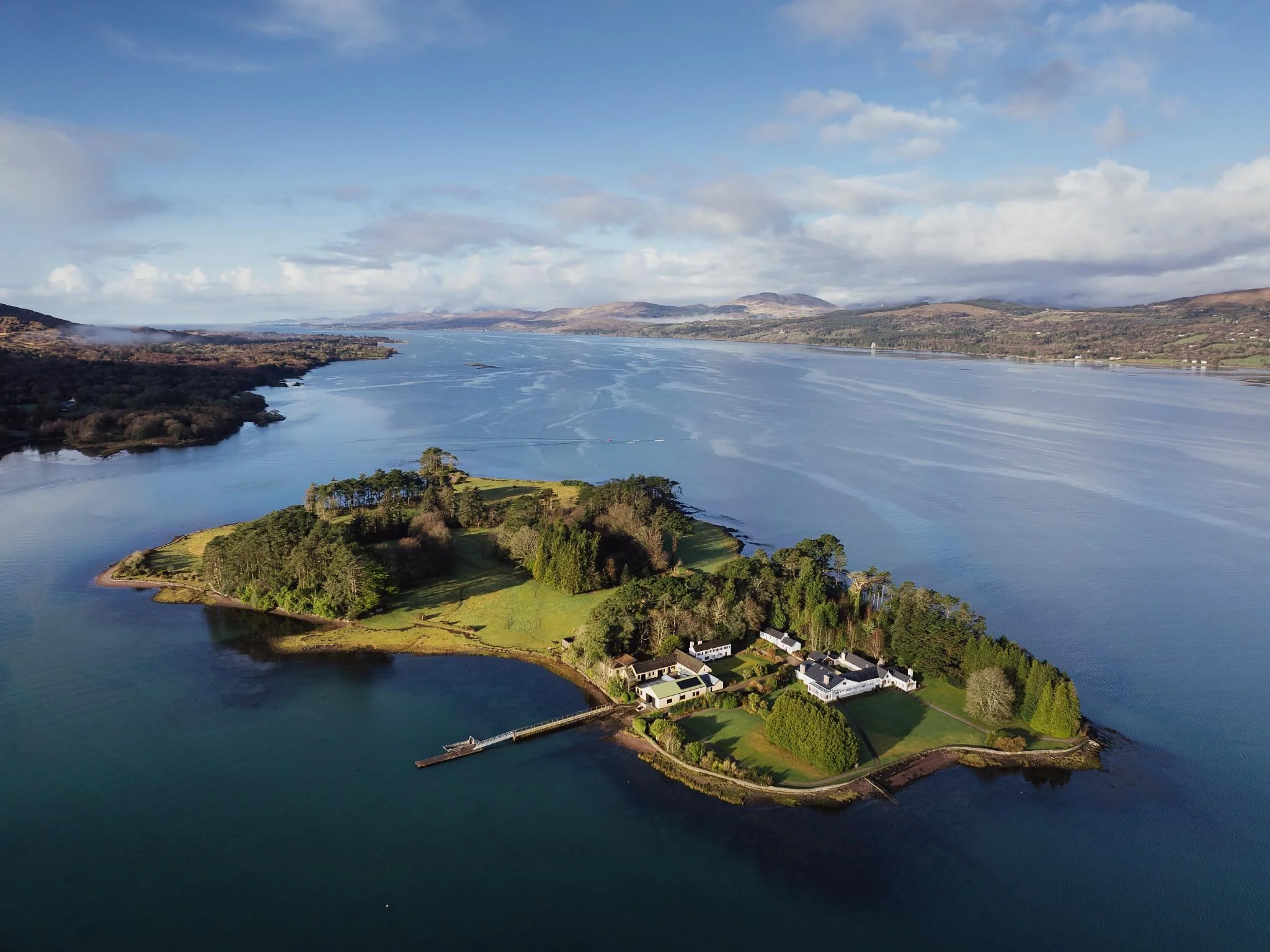 Aerial drone view of Dinish Island near Dawros on the Beara Peninsula, showing the calm blue waters of Kenmare Bay.
