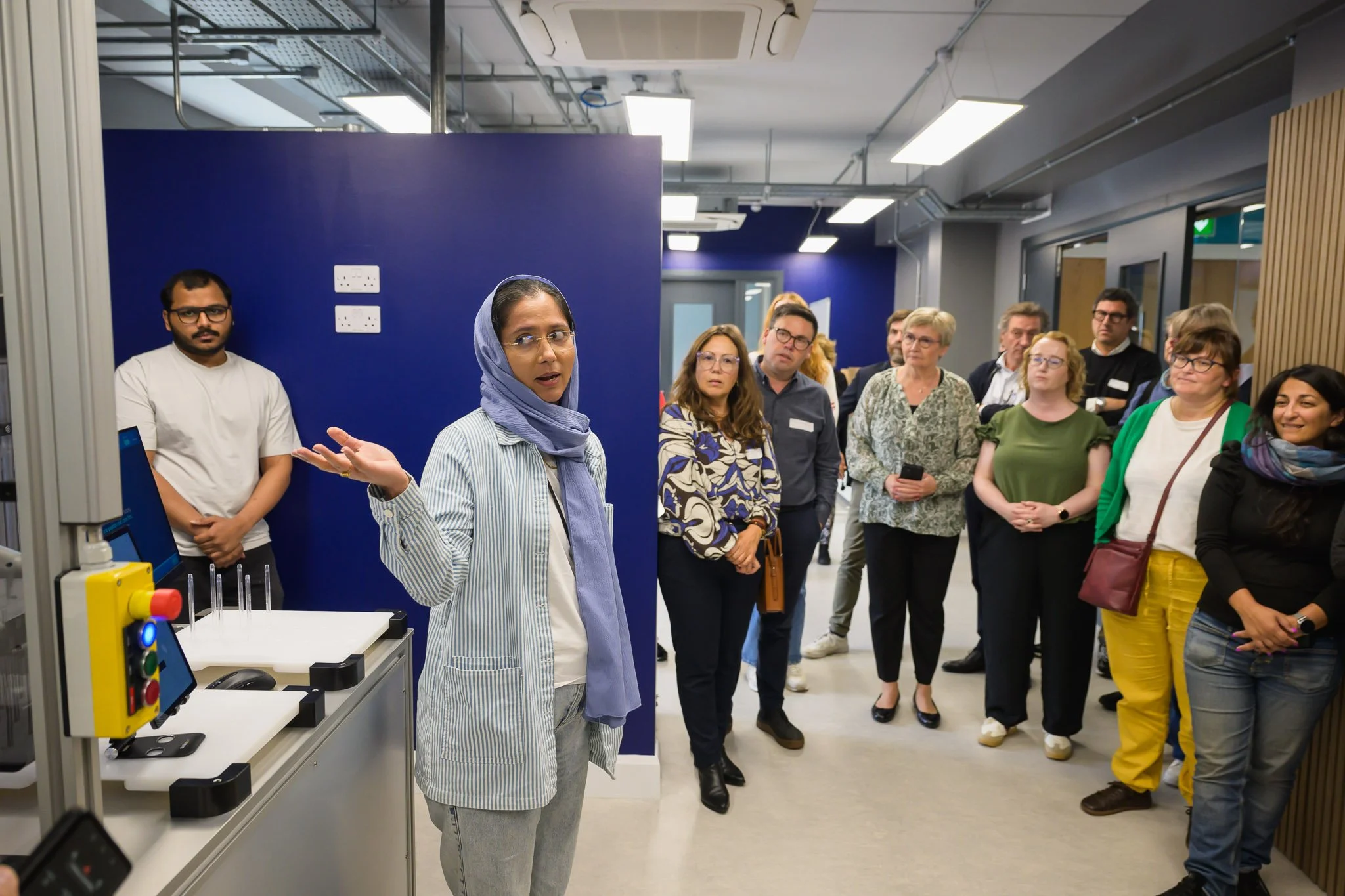 A guide explaining lab equipment to delegates during a facility tour at the Western Development Commission REWARD conference