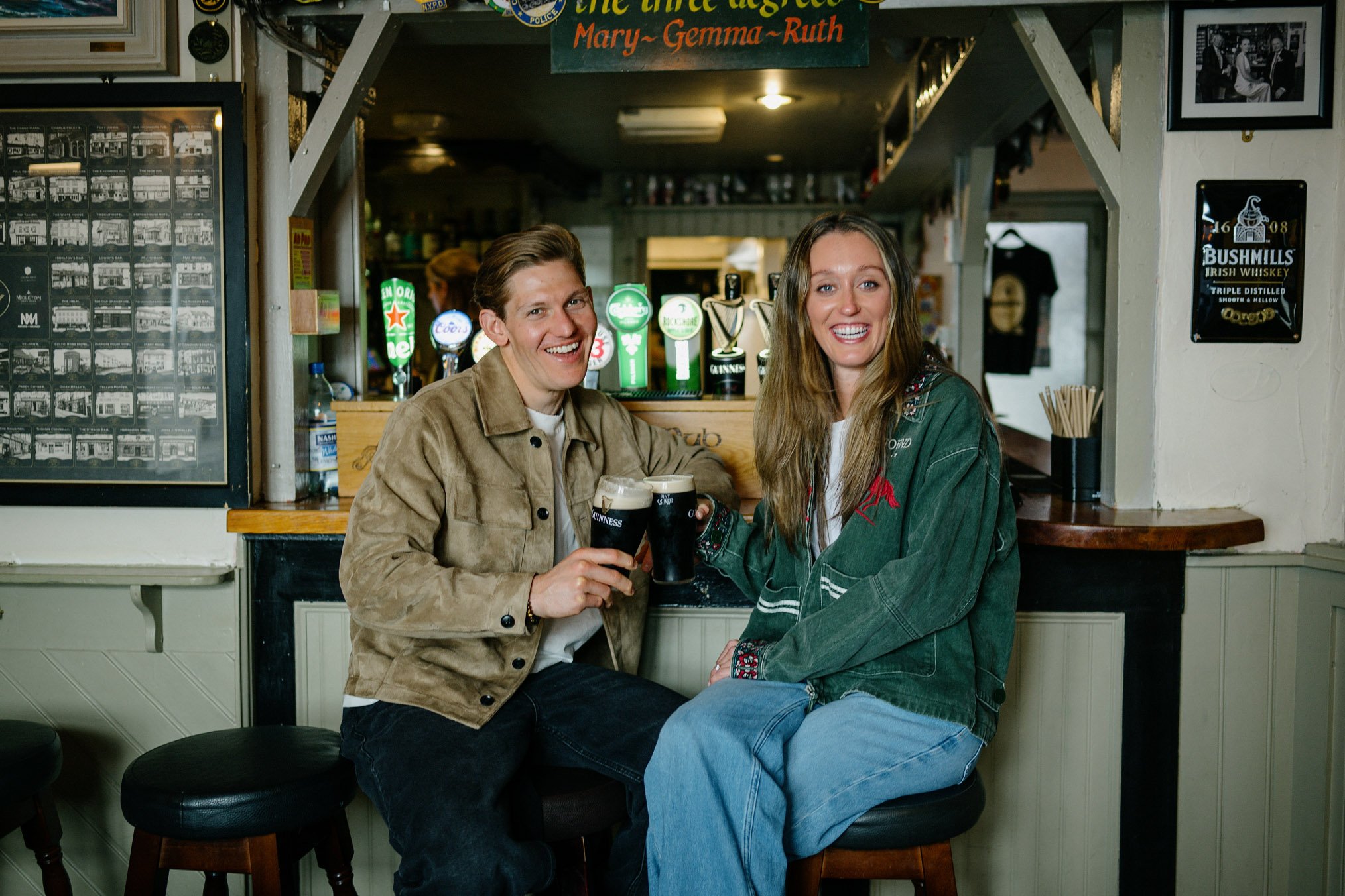 Newly engaged couple raising a toast with two pints of Guinness at McDermott's, a traditional family-run pub in Doolin, County Clare
