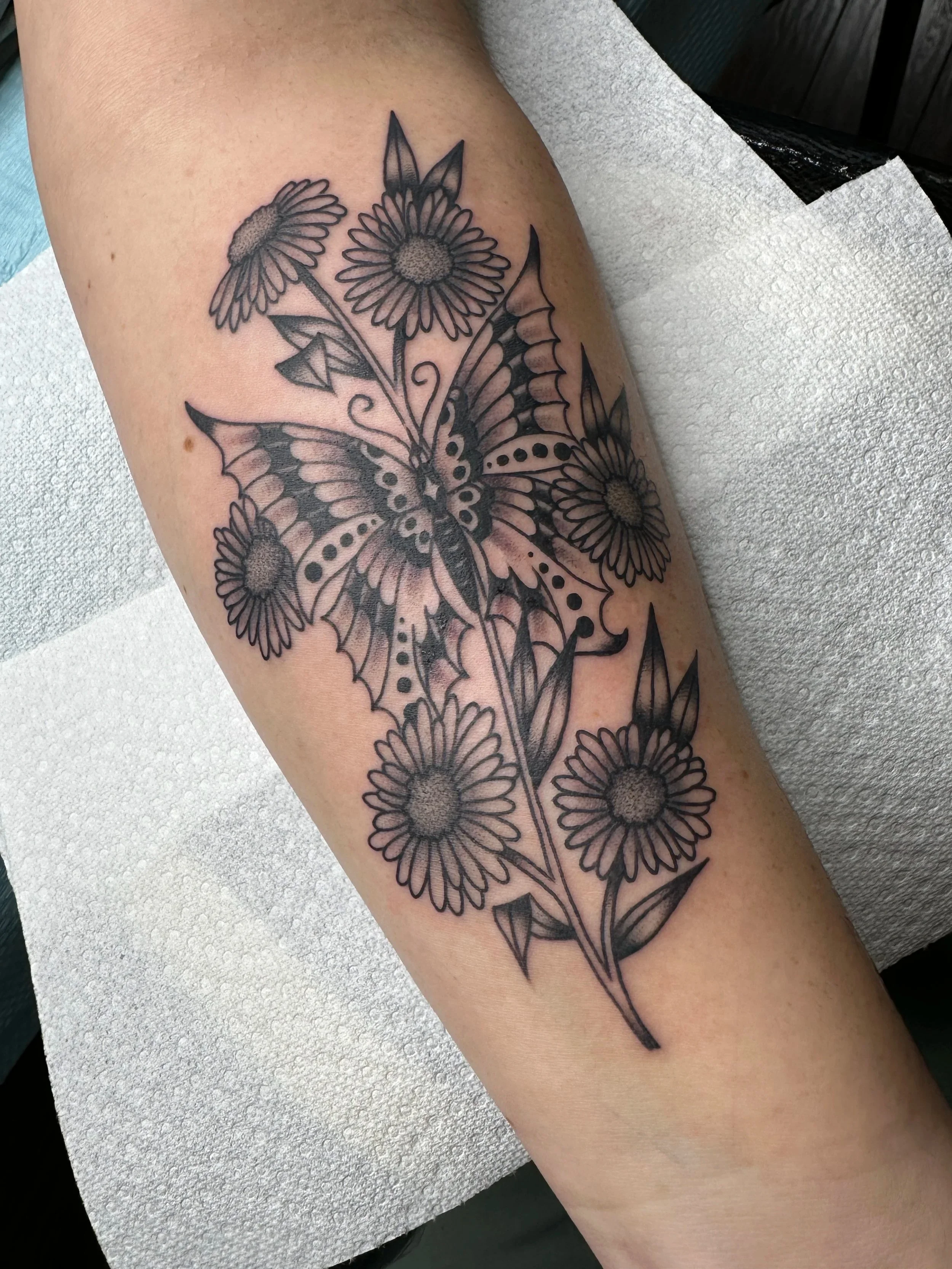 If you don’t have a butterfly tattoo, I highly suggest getting one. This one is mixed in with a bouquet of daisies.