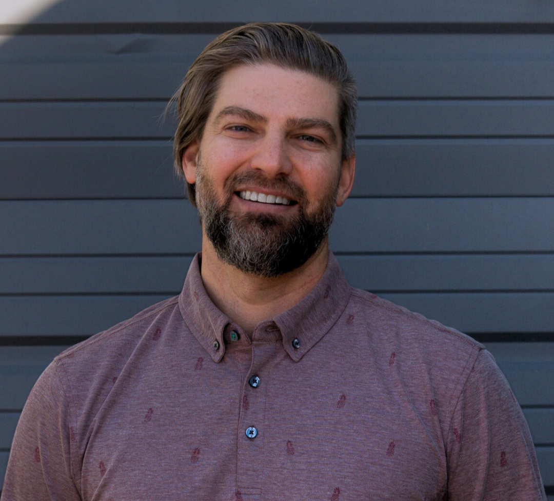 Bryan Rusin, Owner and General Manager of Optimum Golf Denver, smiling in a professional headshot. Experienced golf instructor and amateur competitor in Colorado Golf Association events.