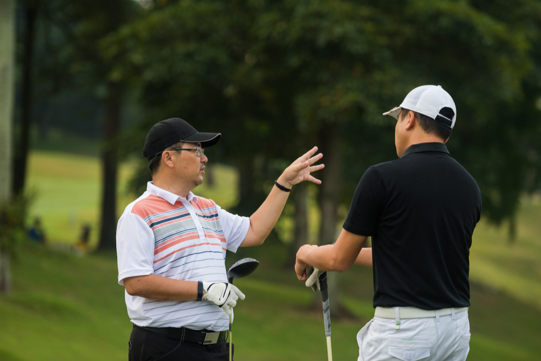 Golf coach giving instruction to a golfer on the course, demonstrating how coaching improves consistency even when things are going well.