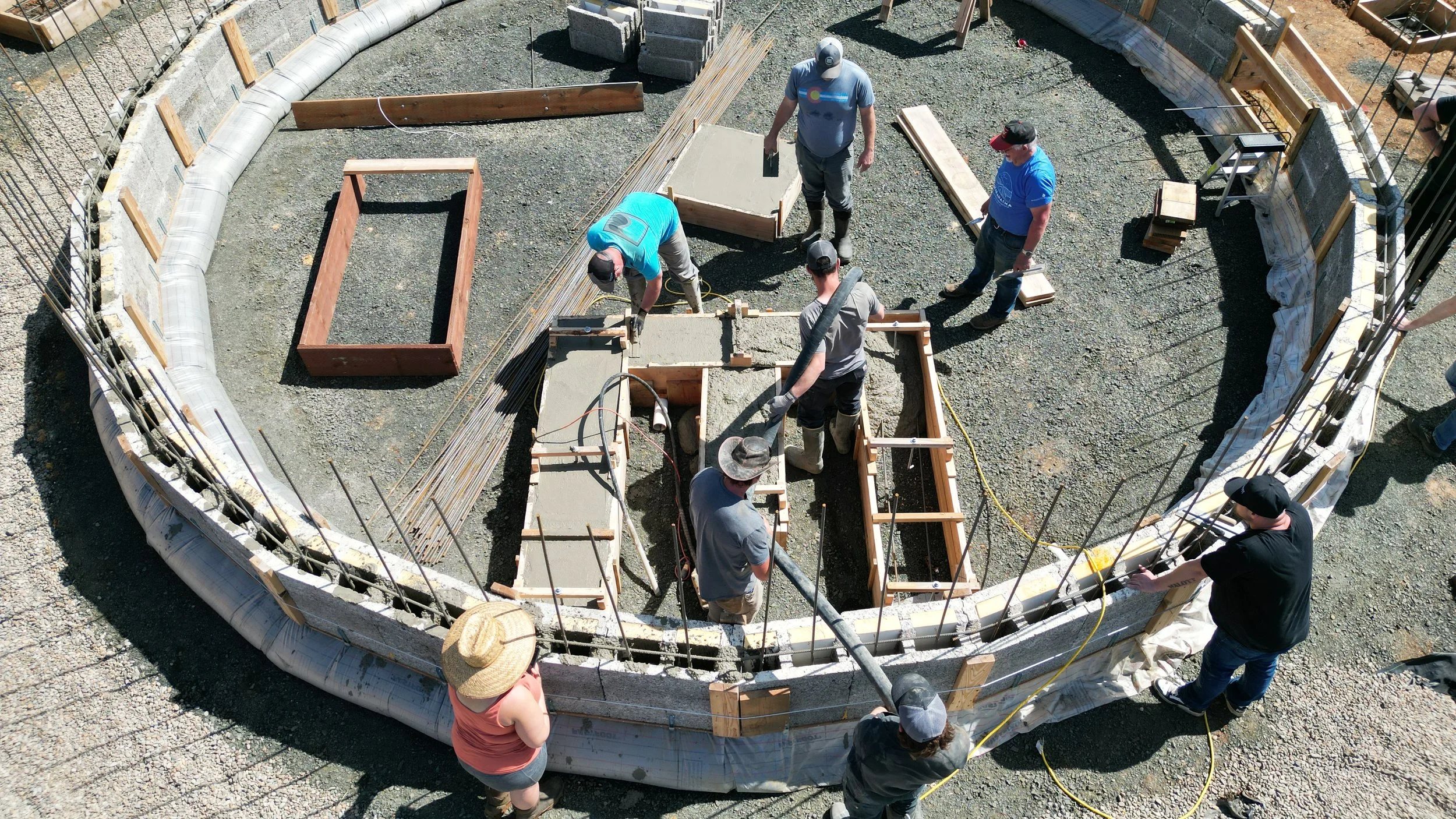 Workers pouring concrete into forms.