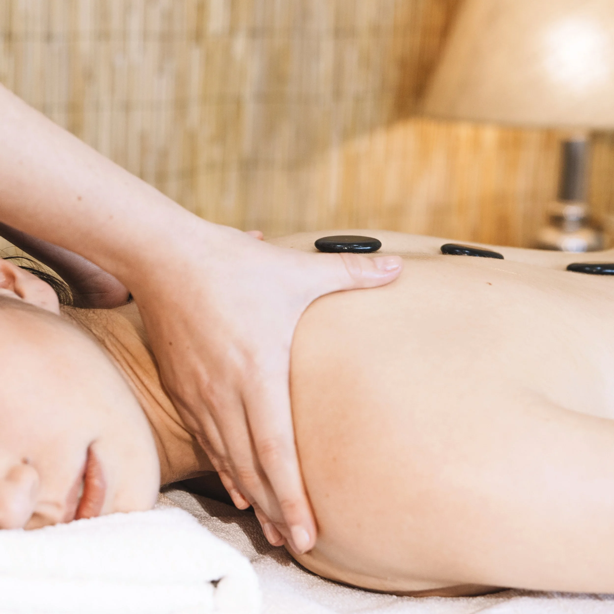 Soothing hot stone massage therapy at River Nails and Spa in Great Falls, Virginia, featuring a tranquil ambiance for relaxation and rejuvenation with professional masseuses dedicated to providing exceptional wellness experiences.
