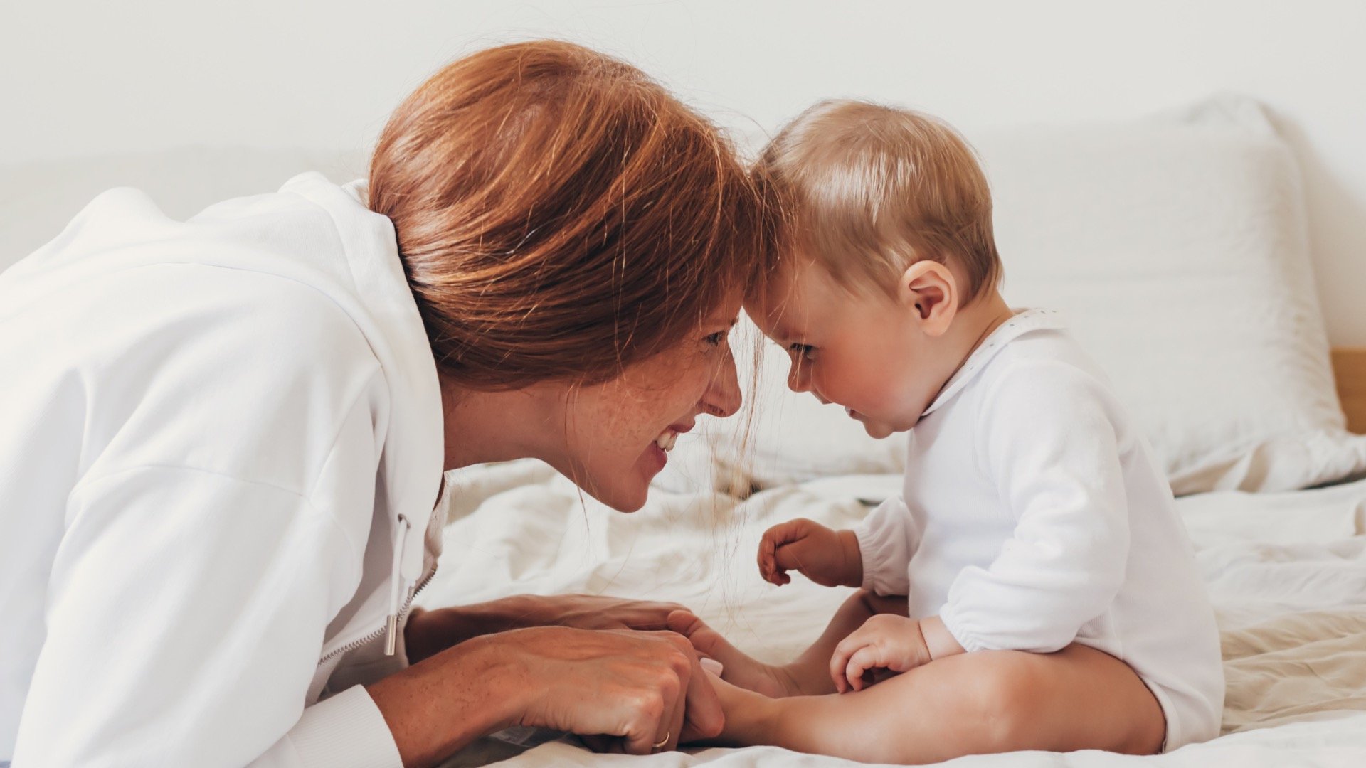 Mom smiling at baby while putting foreheads together and building sleep skills