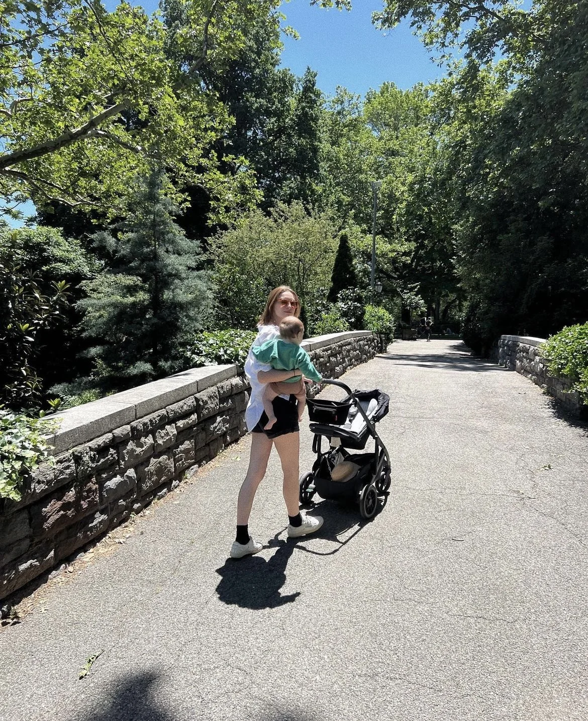 New York City Mom walking through Central Park with her six month old baby. Pushing Uppababy Stroller