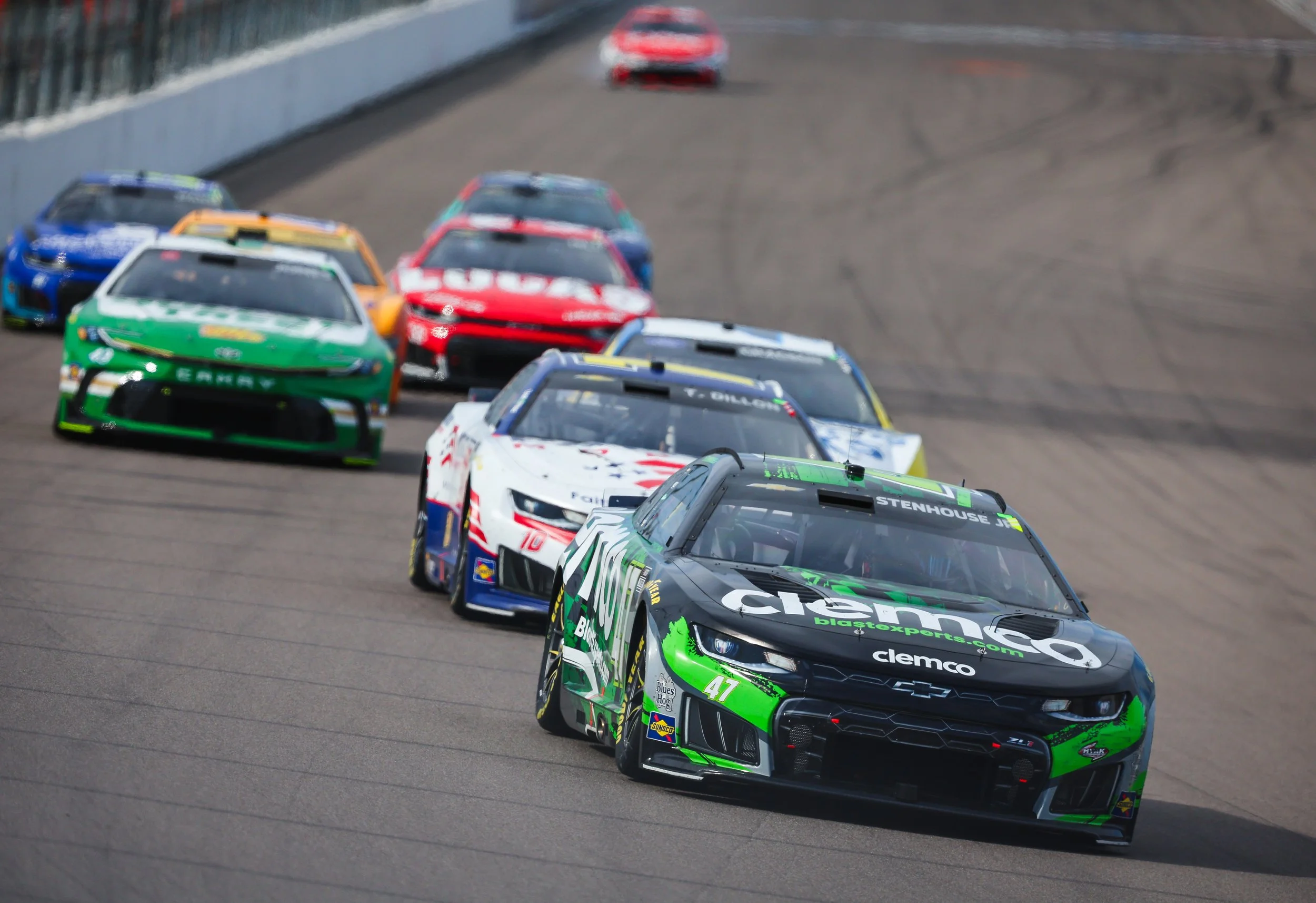 NASCAR racing, the Green Machine battling for position with other drivers on the track the track with other drivers