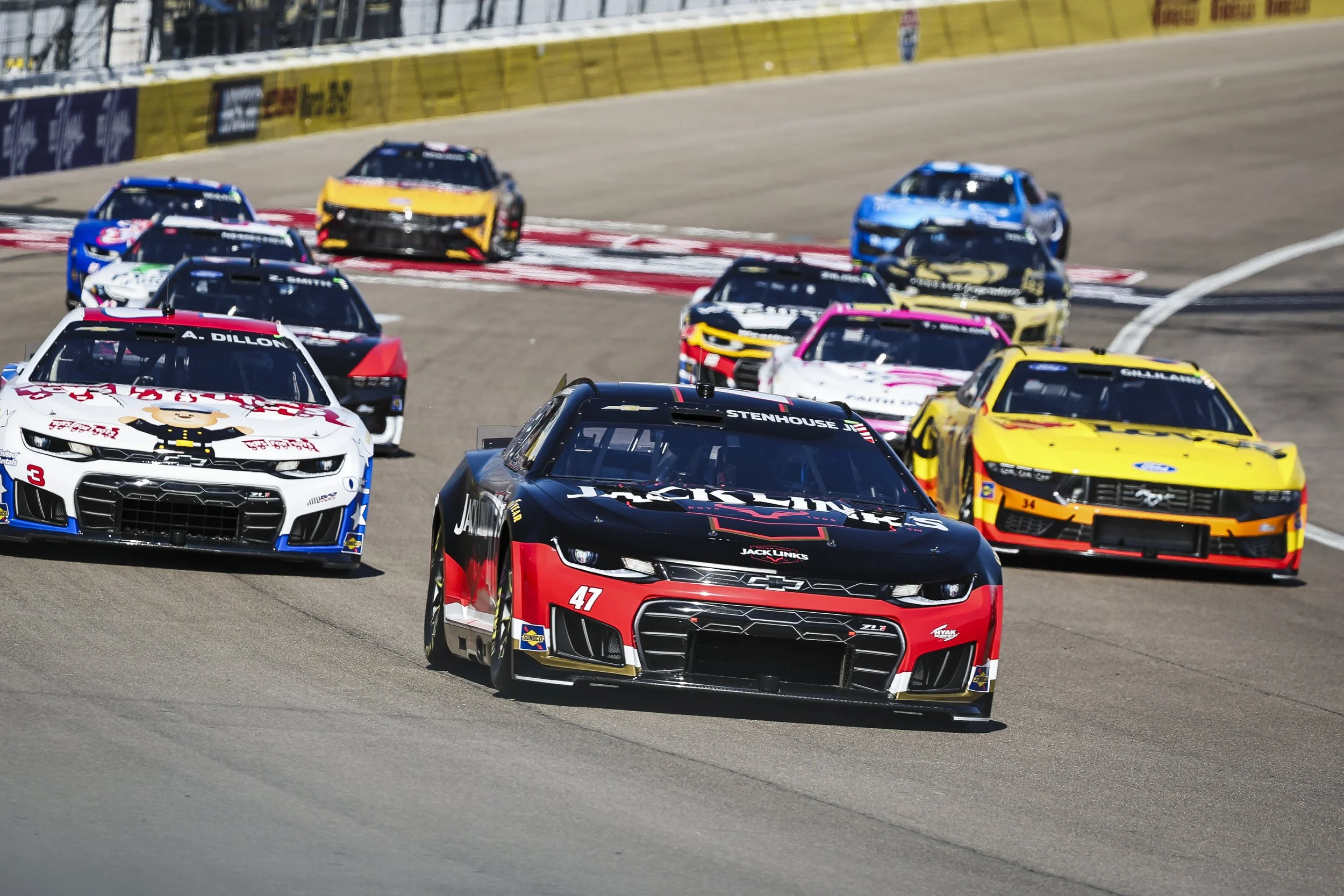 NASCAR cup series racecars on a grey oval track at the South Point 400 in Las Vegas