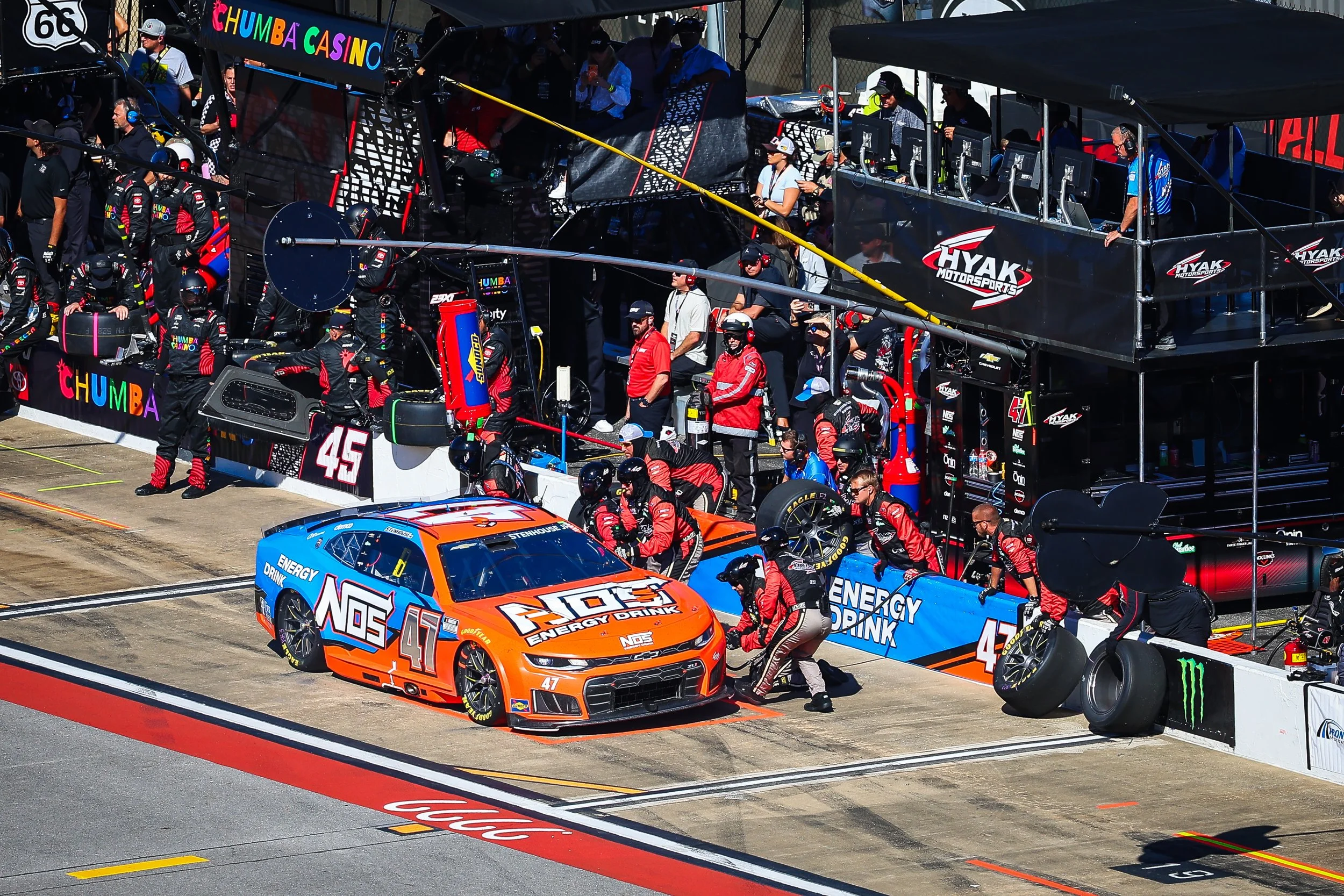 Blue and Orange Stock car on pit row for fuel and tire change