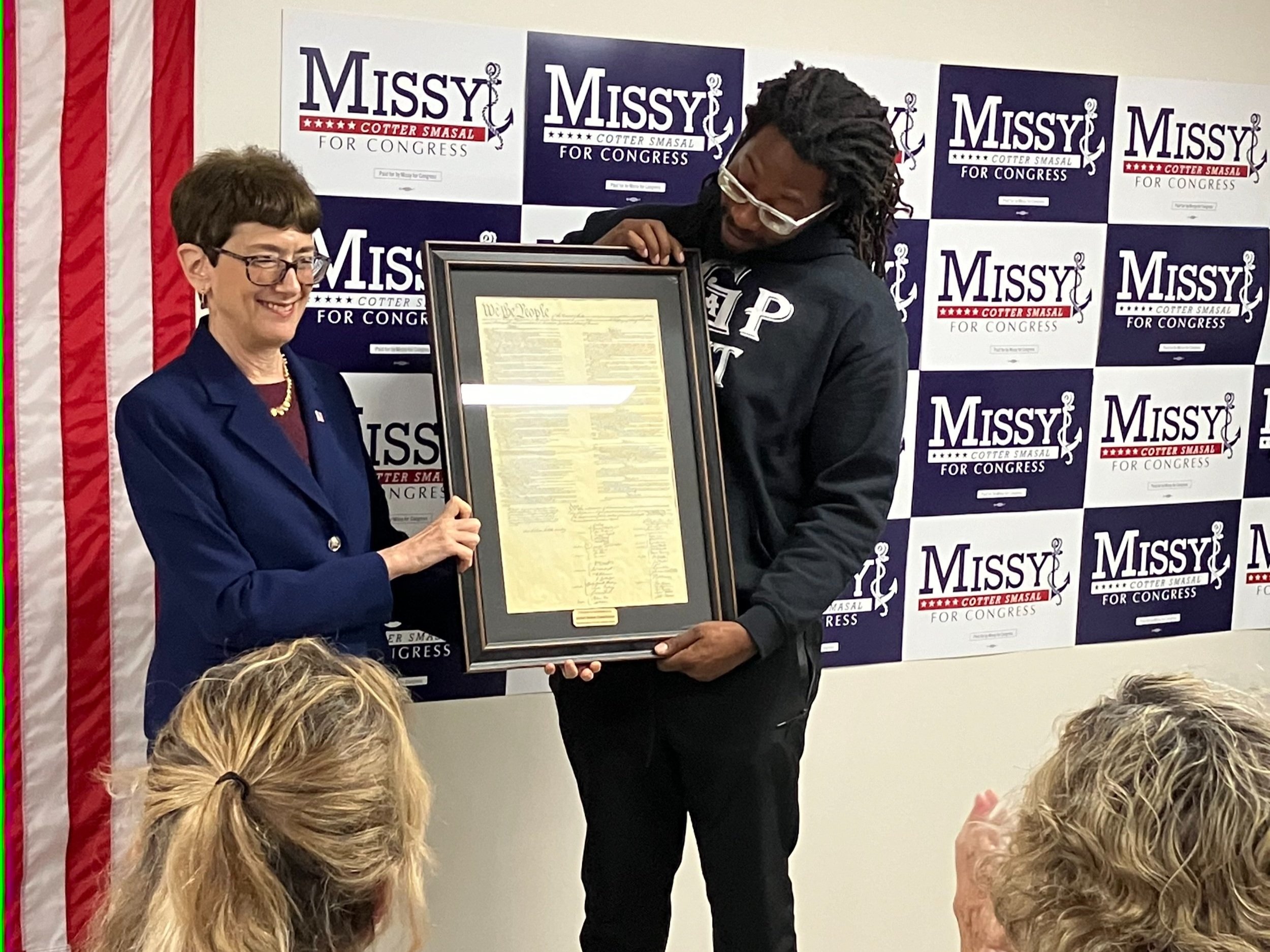 Retired Ambassador Judith Cefkin presenting framed U.S. Constitution for Missy Cotter-Smasal to campaign staffer on her behalf