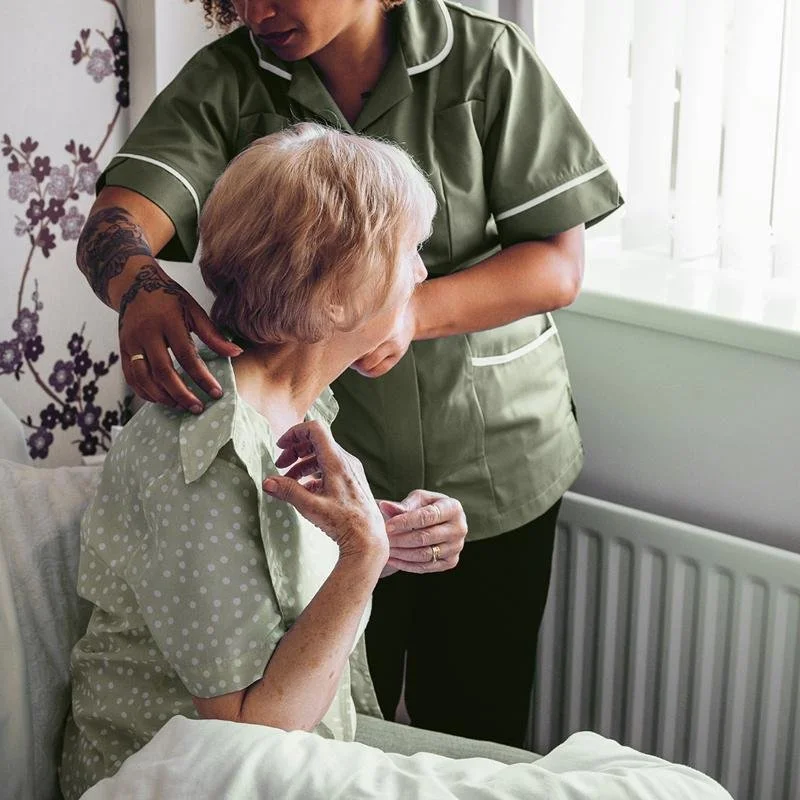 Client being assisted by caregiver with dressing