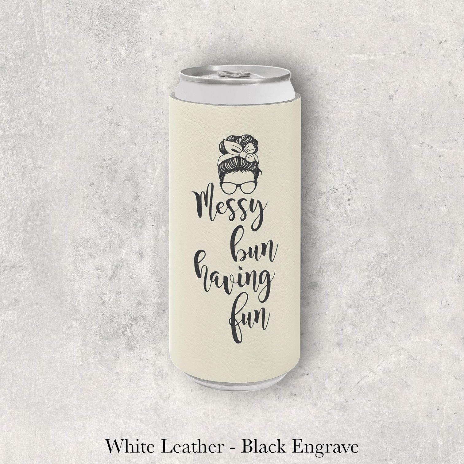 White leather slim can coozie with black laser-engraved “Messy Bun Having Fun” text and icon, engraved by Lazeric