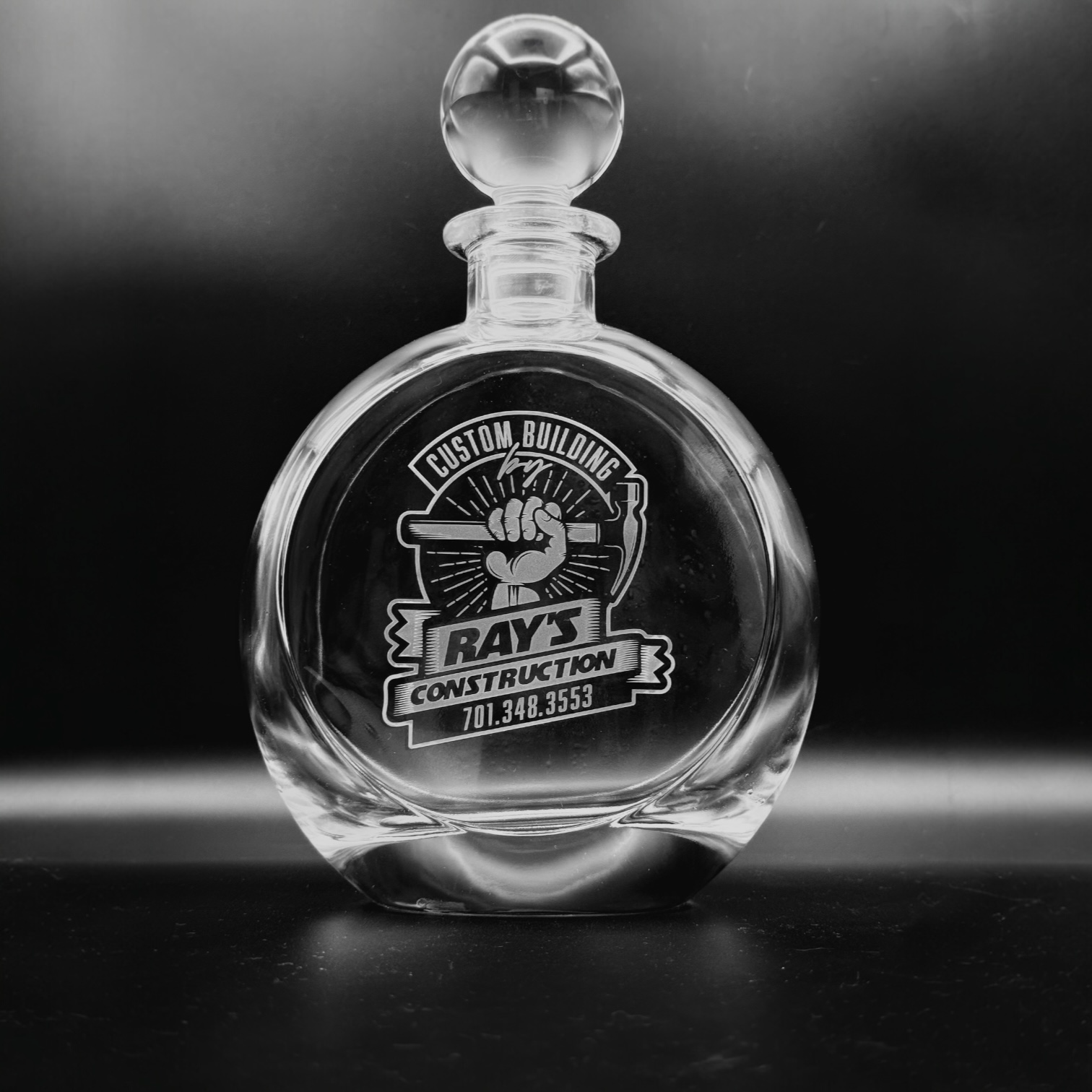 Laser engraved round glass decanter with custom logo, engraved by Lazeric