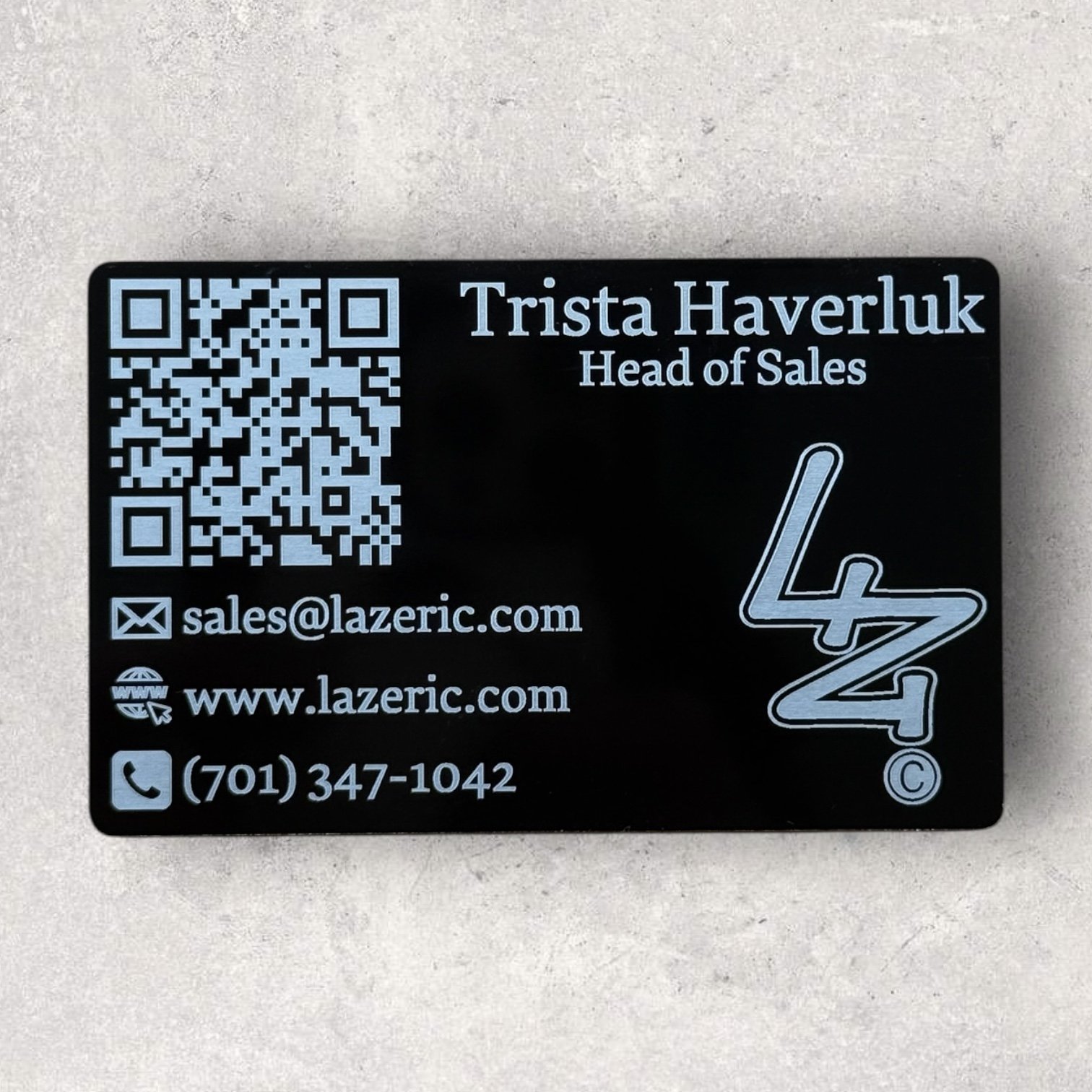 Laser engraved black metal business card for Trista Haverluk of Lazeric, featuring contact info, logo, and QR code - Lazeric