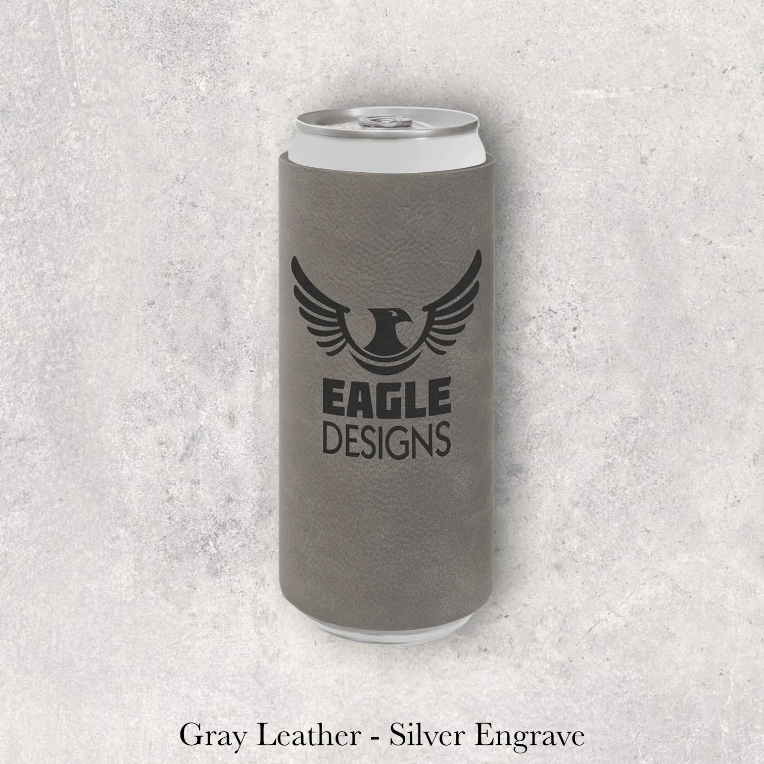 Gray leather slim can coozie with silver laser-engraved Eagle Designs winged logo, engraved by Lazeric